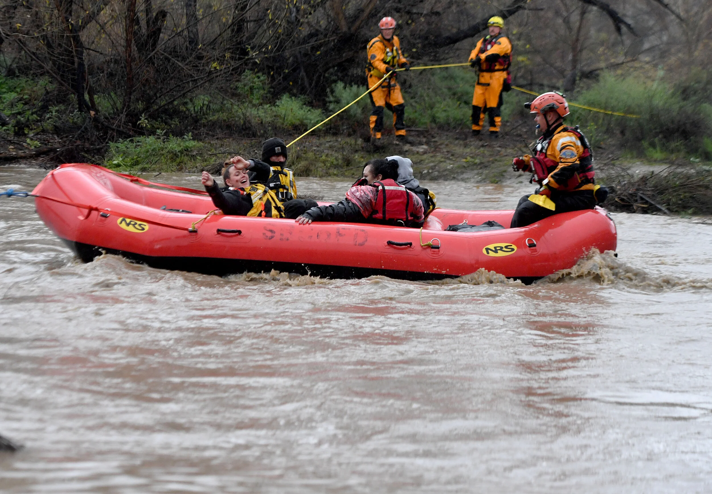 A rescued woman reacts as she is pulled across the rain swollen Santa Ana River byA San Bernardino County Fire swift rescue team Thursday, February 14, 2019.  