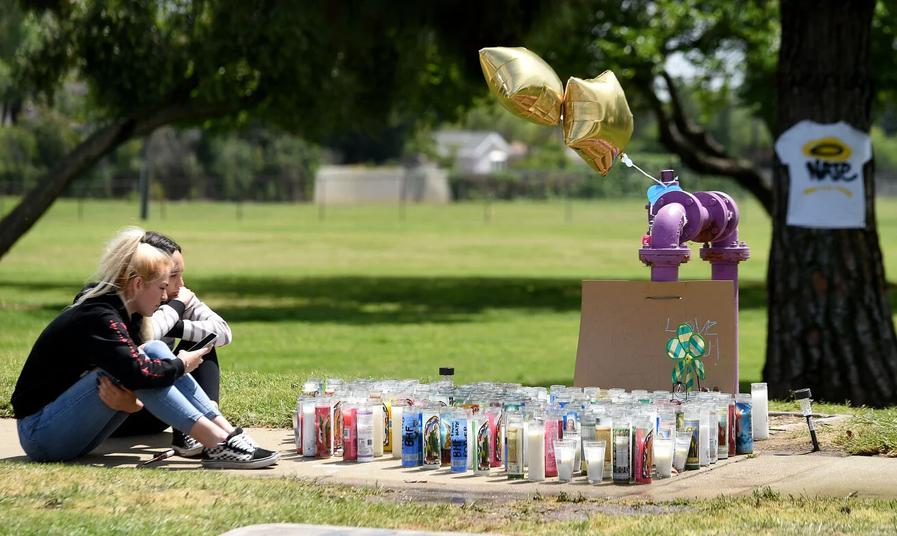  A pair of young girls, who asked not to be identified, light memorial candles for their friend Nathan Shamblin, 18, who was shot and killed Saturday night in the 1500 block of North Shelley Avenue in Upland during a baby shower. Monday, April 15, 20