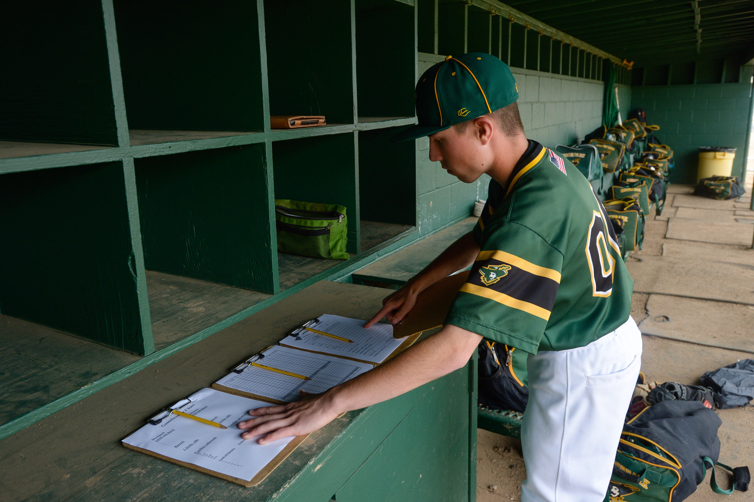 Moorpark High baseball's student manager Benedict Yaspelkis IV lays out clipboards for coaches before the Musketeers game with Oak Park on April 5, 2019. As manager, Yaspelkis is responsible for getting the field prepared, setting up the dugout and