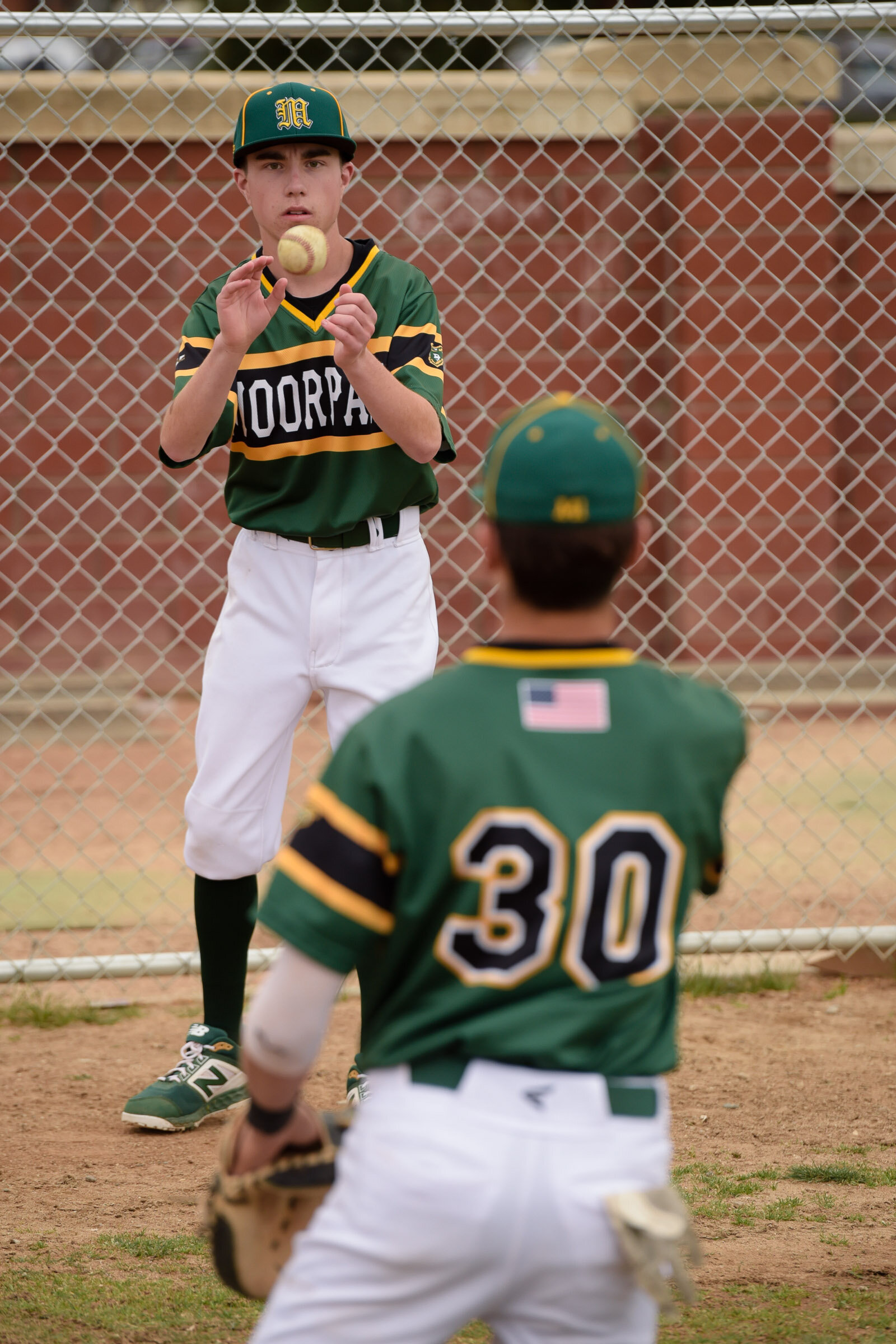Moorpark High baseball's student manager Benedict Yaspelkis IV helps warm up Robbie Ayers before their game with Oak Park on April 5, 2019.