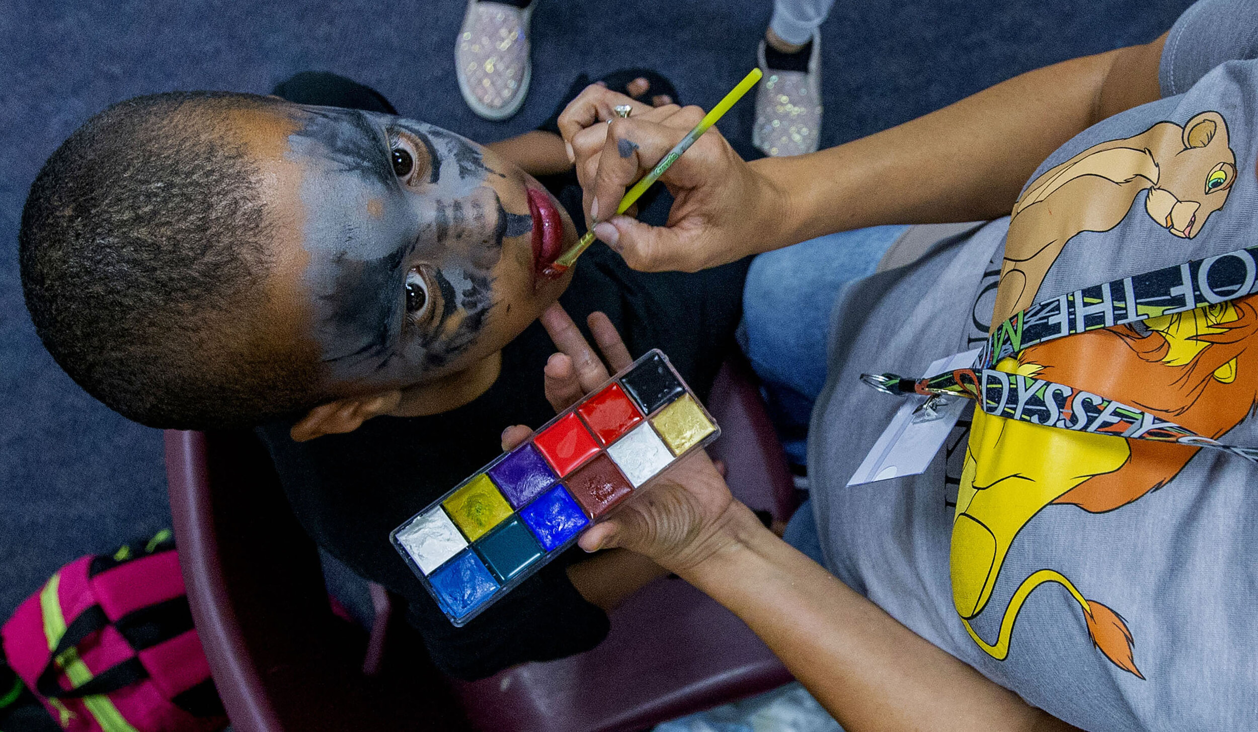 Volunteer makeup artist Xochitl Avila prepares the face of cast member during opening night of The Lion King performed by Summer Arts Academy at Vista del Lago High School in Moreno Valley on Thursday, July 25, 2019.