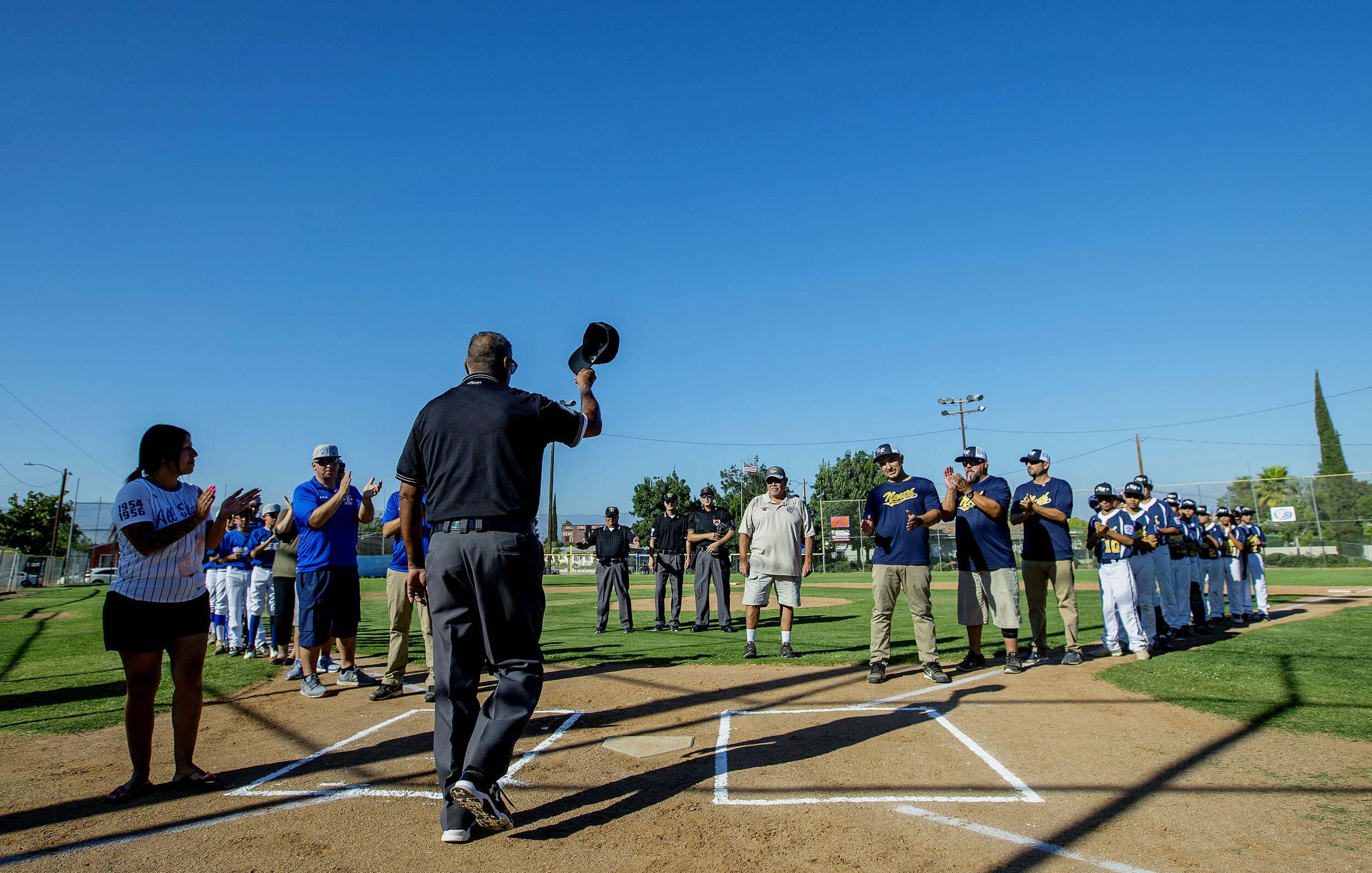 2019 Little League World Series District 21umpire Anthony Estrada tips his hat as he is introduced to players and fans before the first game of the playoffs for the Little League World Series at Ken Hubbs Memorial Little League Park in Colton on Mon