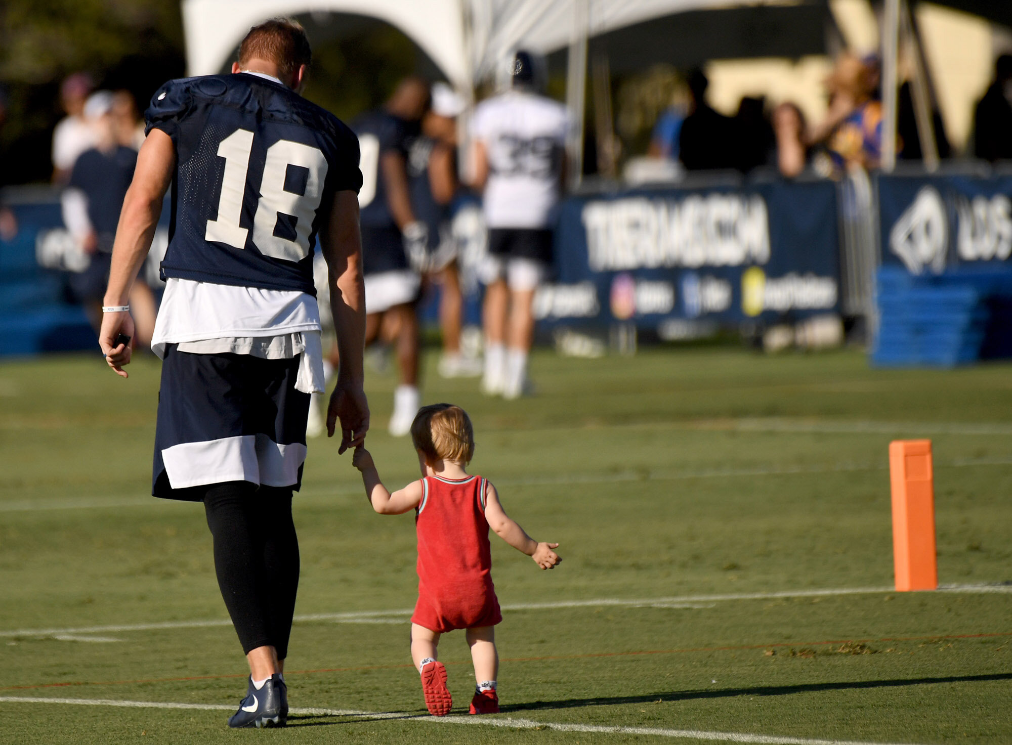 Wide receiver Cooper Kupp #18 of the Los Angeles Rams walks off the field with his son June after practice during the Los Angeles Rams training camp on the campus of UC Irvine on Saturday, July 27, 2019 in Irvine, California.  
