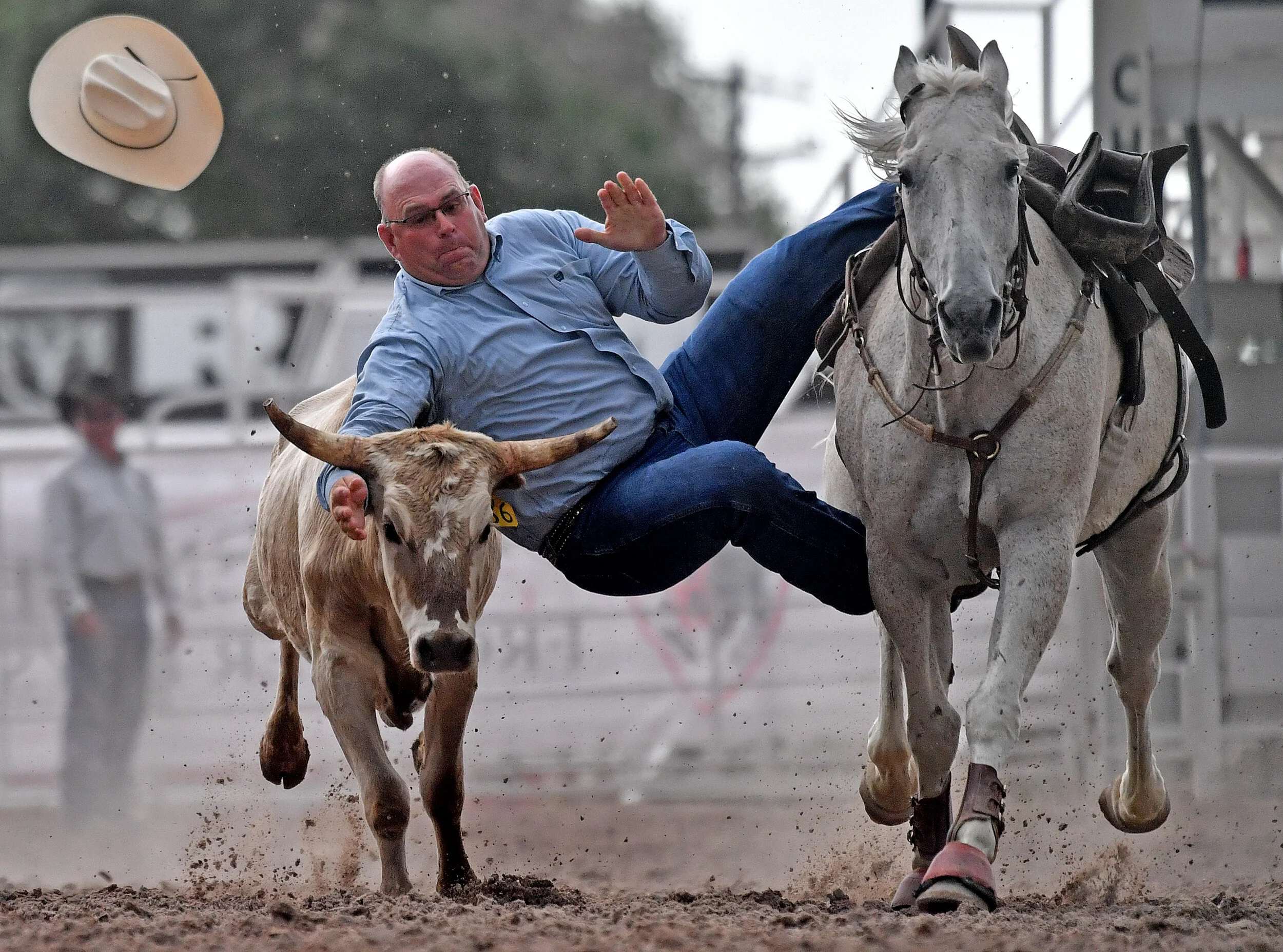  Dean Finnerty, from Wheatland, Wyoming, loses his hat as he competes in the Steer Wrestling event Wednesday July 24, 2019 during the 123rd Cheyenne Frontier Days Rodeo in Cheyenne, Wyoming.  