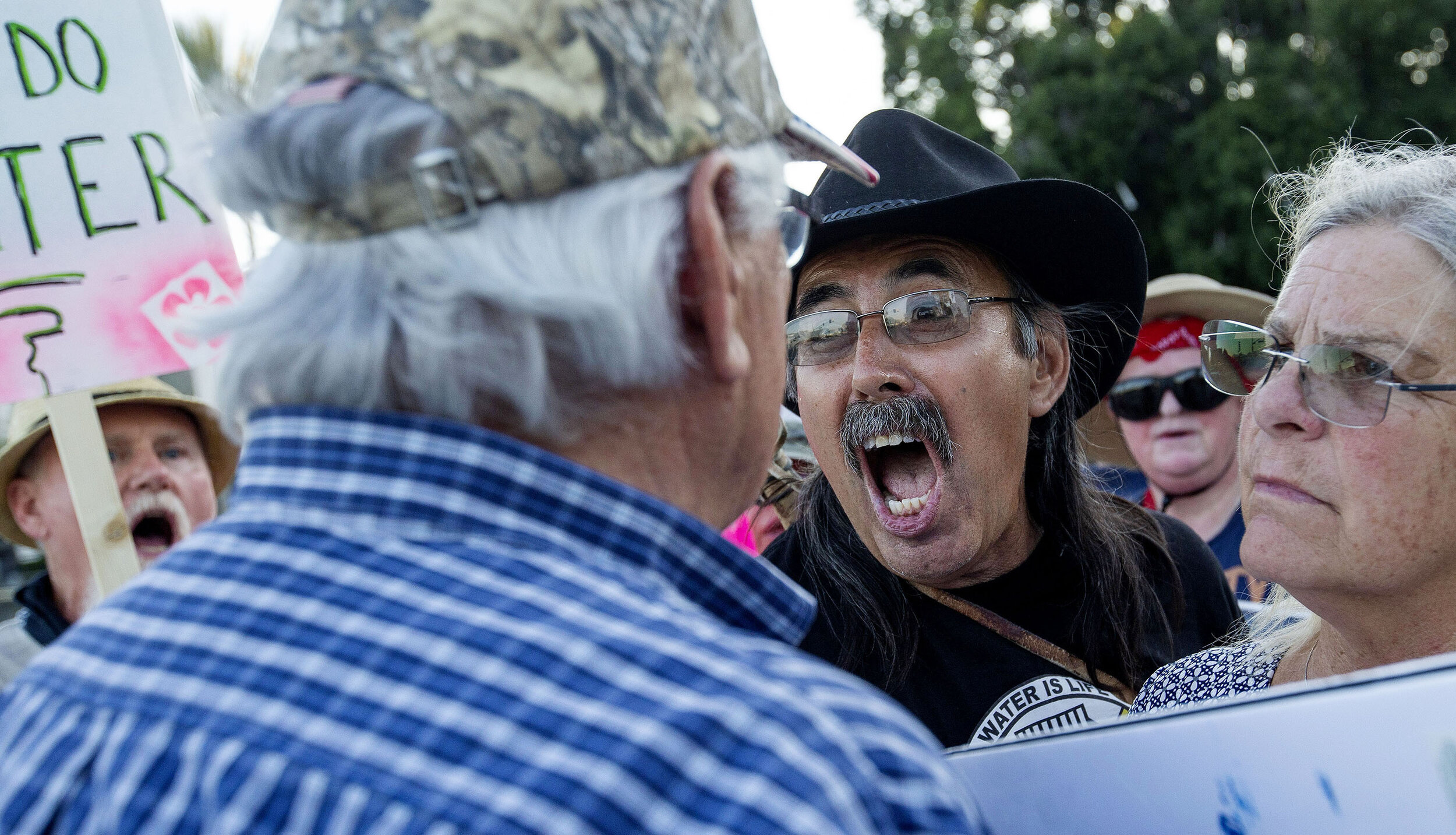 Immigrant detention centers protester Dan Romero, center yells, "Love Love L" at a Trump supporter who did not want to be identified outside the outside the U.S. Department of Homeland Security office in San Bernardino on Friday, July 12, 2019.