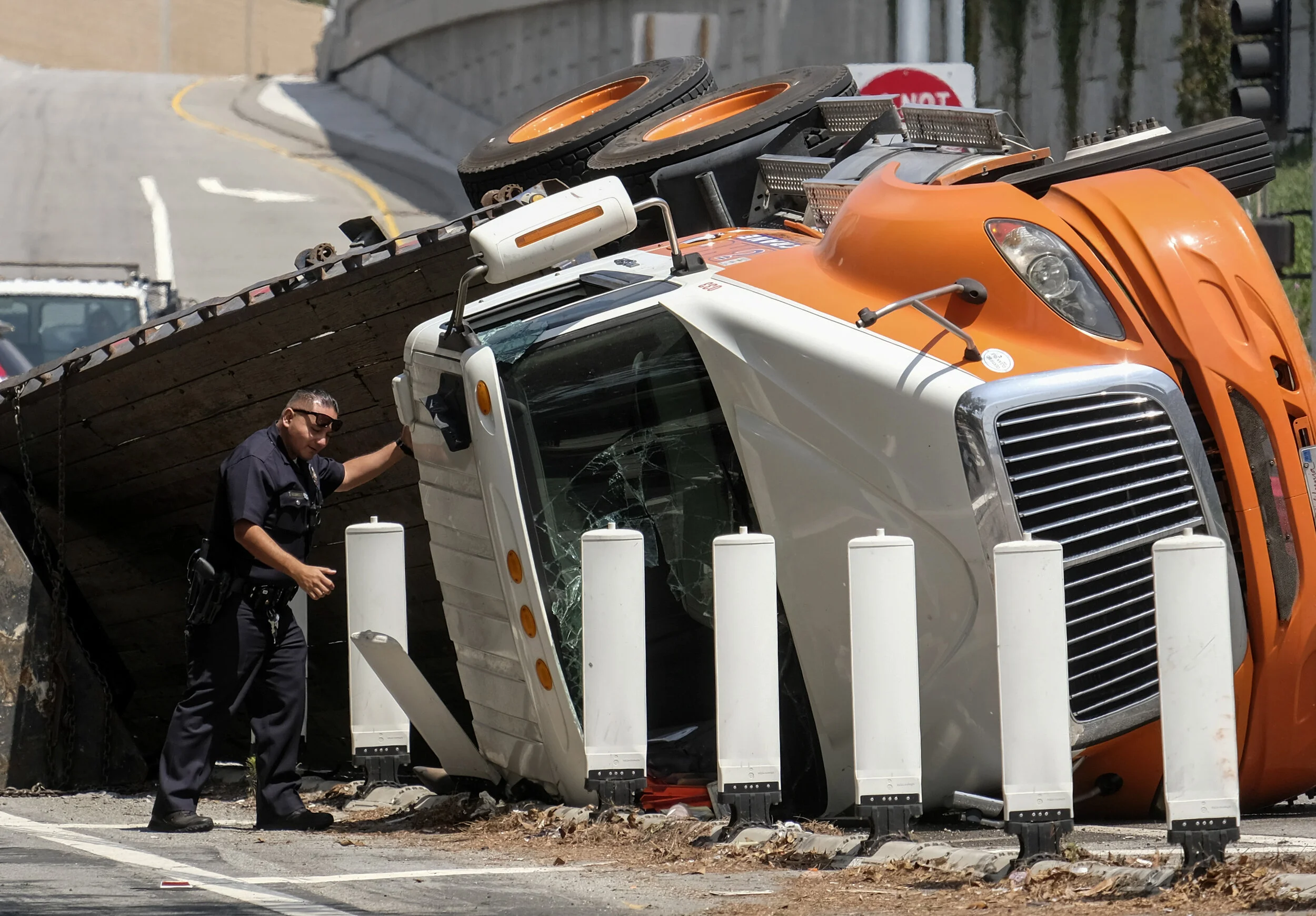  A police officer walks by the scene of a big rig crash on an entrance of I-405 on the Santa Monica Blvd in West Los Angeles. 