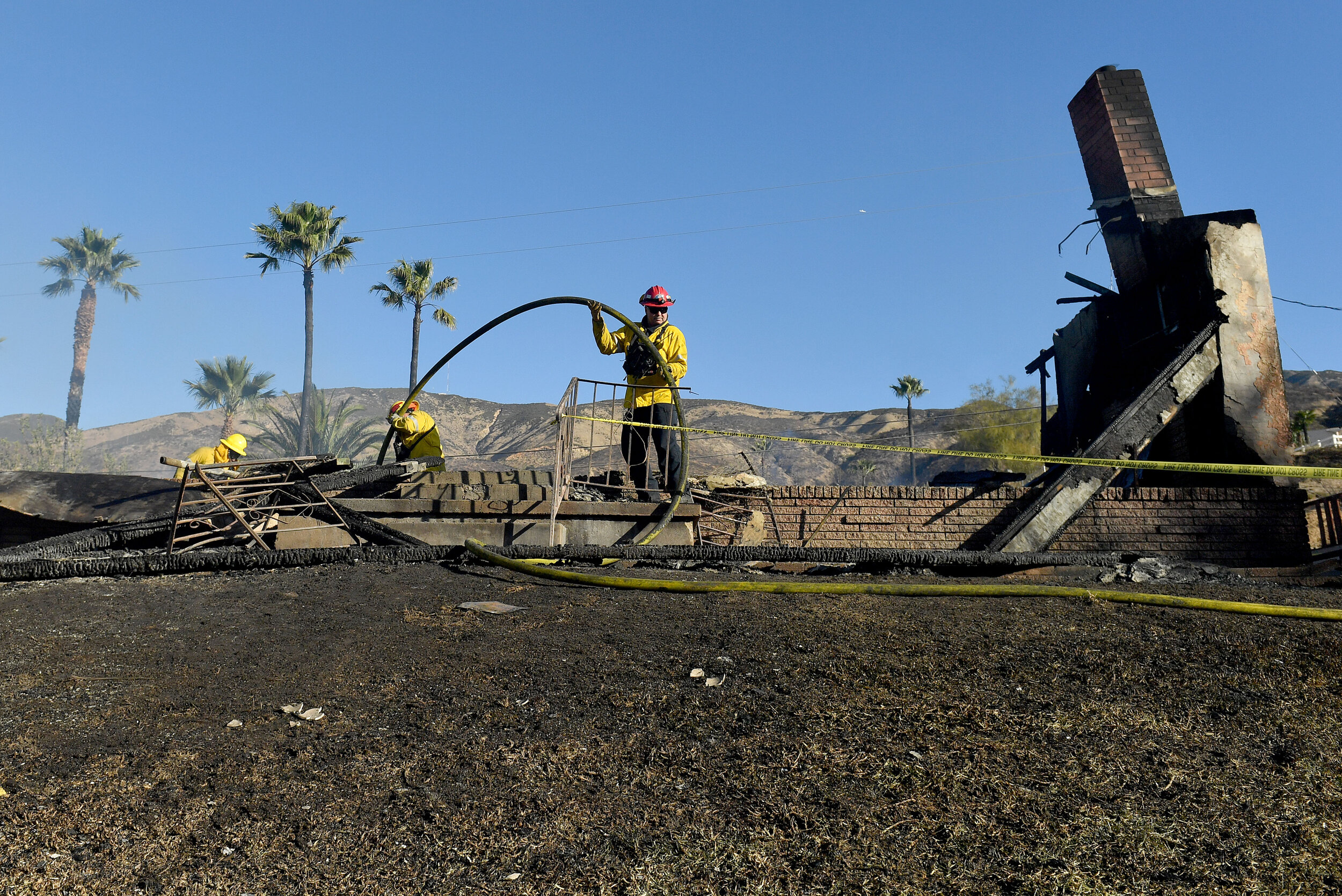  Firefighter work to extinguish hot spots at one of two destroyed homes on Viento Way in San Bernardino Thursday morning Oct. 31, 2019 after the Hillside fire broke out in the early morning hours. At least 5 homes have been destroyed by the wind driv
