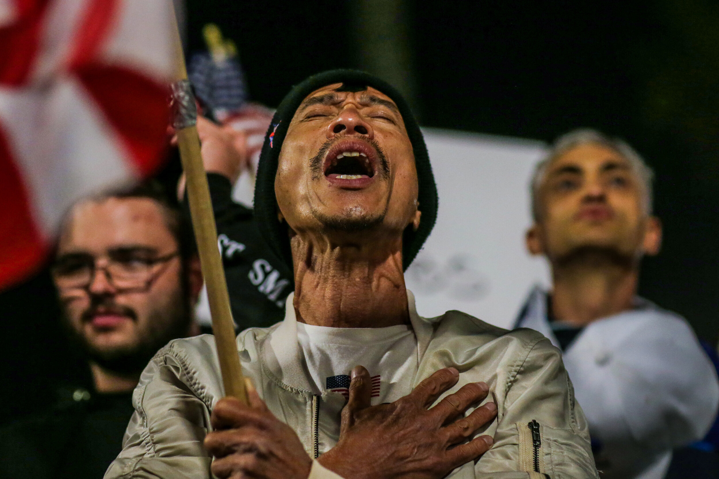  Huntington Beach, CA, Saturday, November 21, 2020 - Bao Tran from Westminster weeps while singing the National Anthem while joining hundreds of others at the pier to protest a State mandated 10 pm to prevent the further spread of Covid-19.    