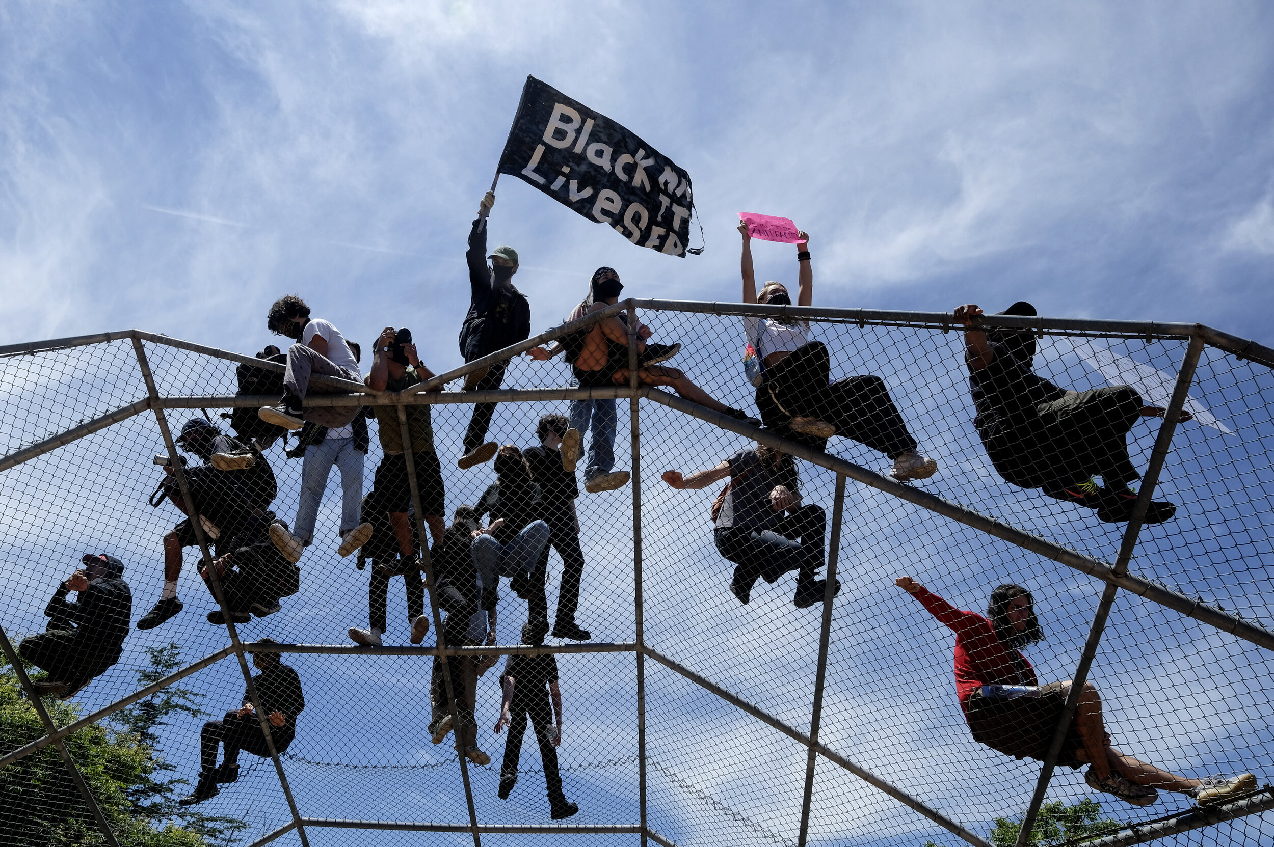  Protesters stand on top of a baseball backstop during a protest over the death of George Floyd, a handcuffed black man in police custody in Minneapolis, in Los Angeles, Saturday, May 30, 2020.The 2020 Black Lives Matter protests across the nation we