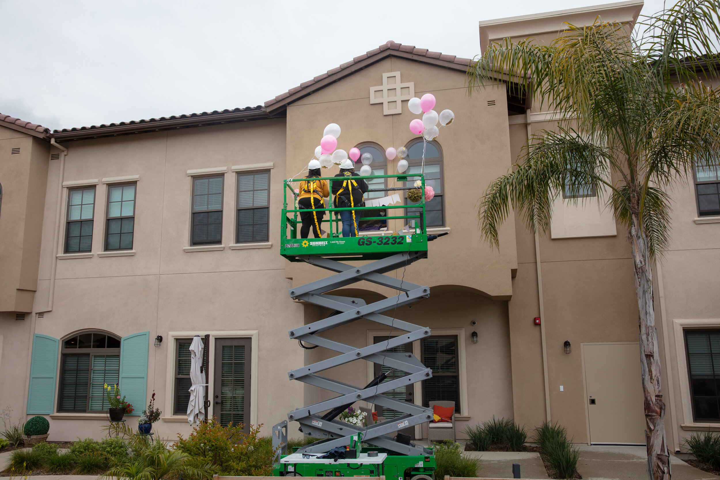  Lucy Cavazos and her daughter Amber, from Huntington Park, use a lift to help celebrate the 91st birthday of Margaret Jones, in the courtyard assisted living facility, The Kensington Redondo Beach, in Redondo Beach, CA, during the coronavirus pandem