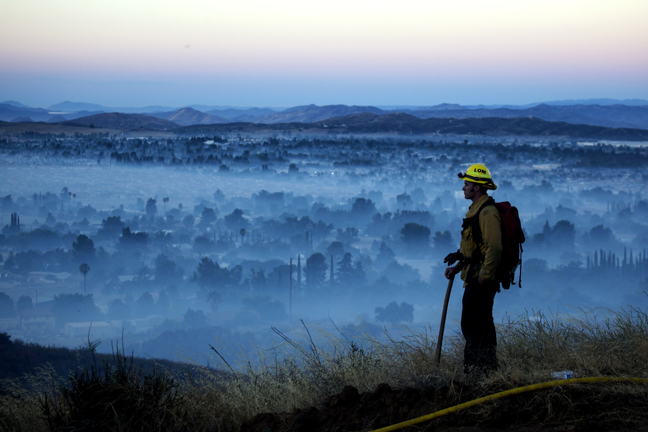  A firefighter watches a brush fire as smoke from the Apple Fire covers the city in Banning, Calif., Saturday, Aug. 1, 2020. The 2020 California wildfire season was characterized by a record-setting year of wildfires that burned across the state of C