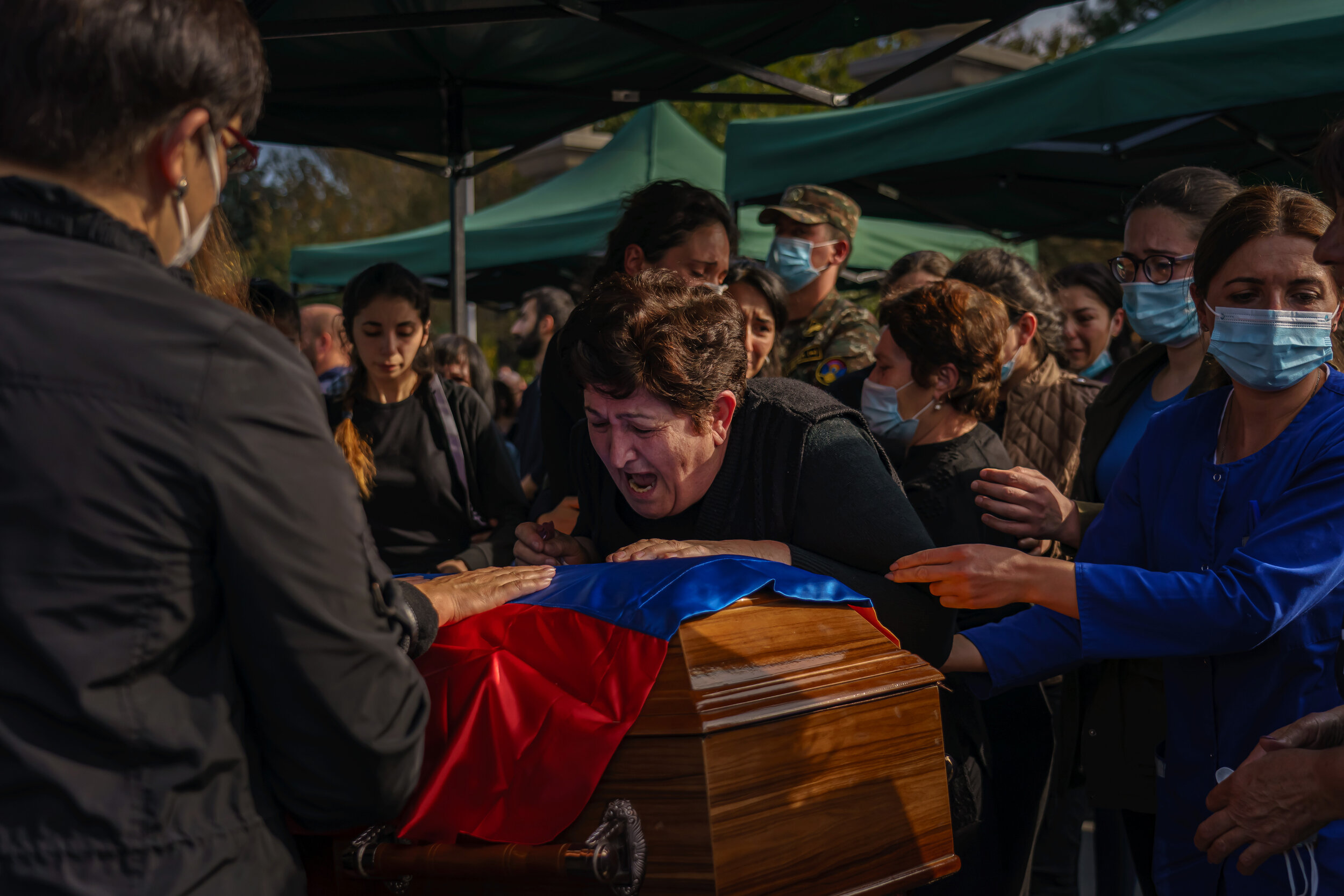  A woman wails over a casket as family and friends surround her to comfort her as they gather to mourn the loss of Kristapor Artin and Suren Vanyan, both volunteer fighters who lost their lives to the Nagorno-Karabakh war, at the Yerablur Military Me