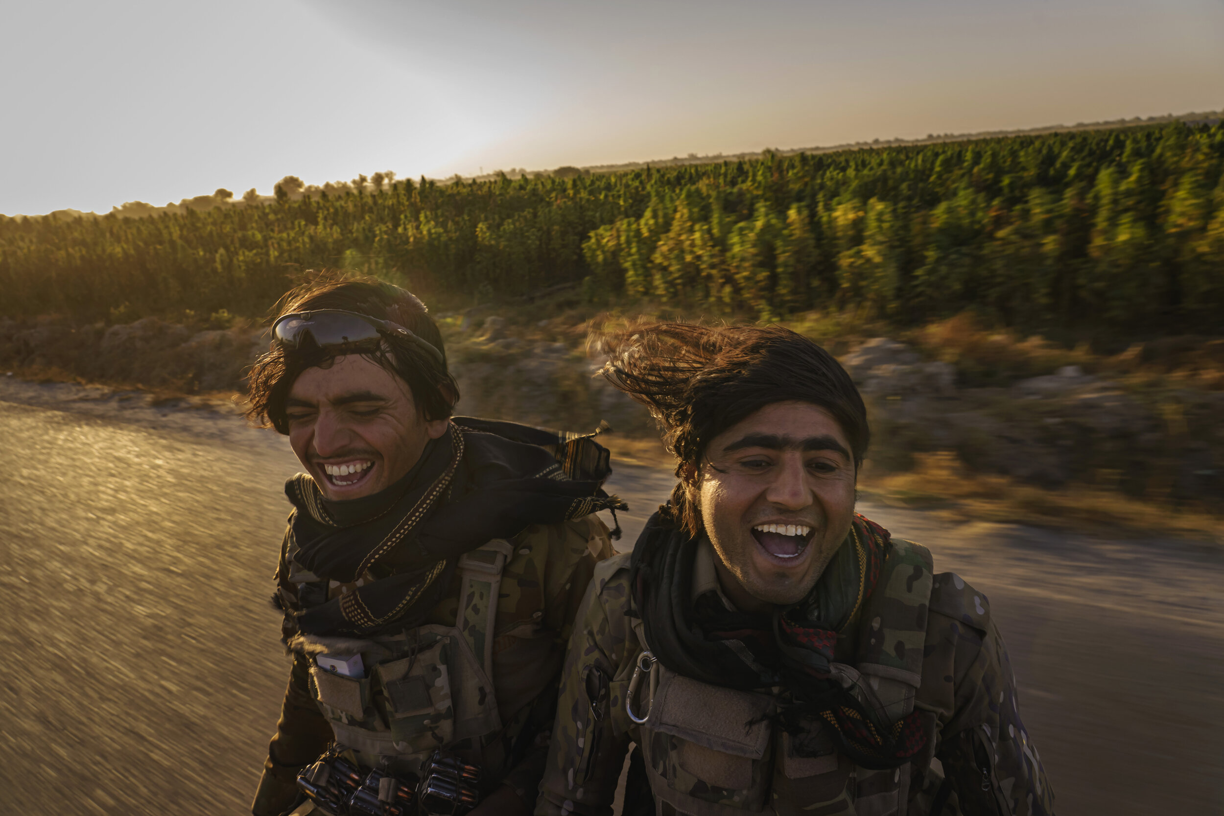  As they roared through villages, past shoulder-high cannabis stalks that filling the air with a sweet fragrance, Hazrat Bilal, 24, right, and other Afghan National Police officers sing a somber melody as they patrol the Panjwai district outside of K