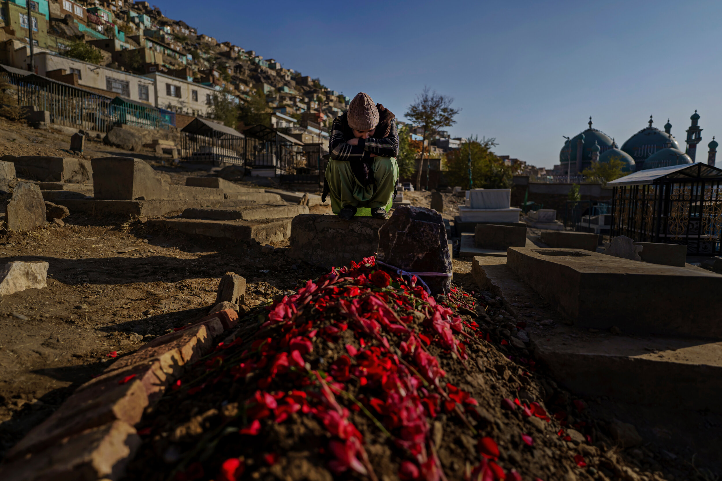  Sayed-Masih Sadaat, 23, would not budge from the head of the grave covered in flower petals as he mourns the death of his cousin, Sayeda Marzia Tahery, a 20-year old public administration and diplomacy student who was killed in the attack on Kabul U