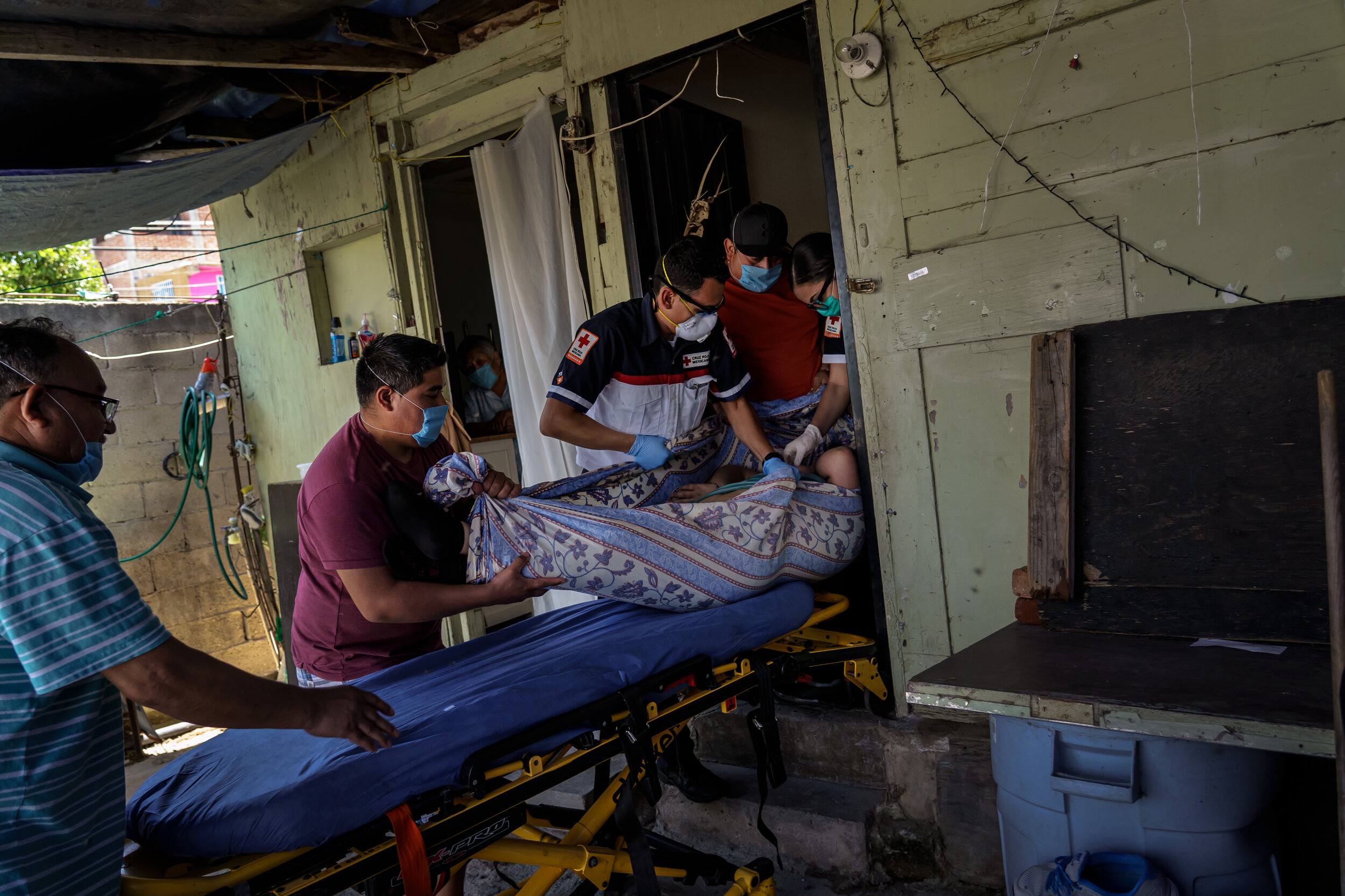  Red Cross paramedics Michael Zavala, 22, center, gets help from the patients' family members as they load the patient onto a stretcher to load into an ambulance for medical transport to a nearby hospital after determining that the patient did not ne