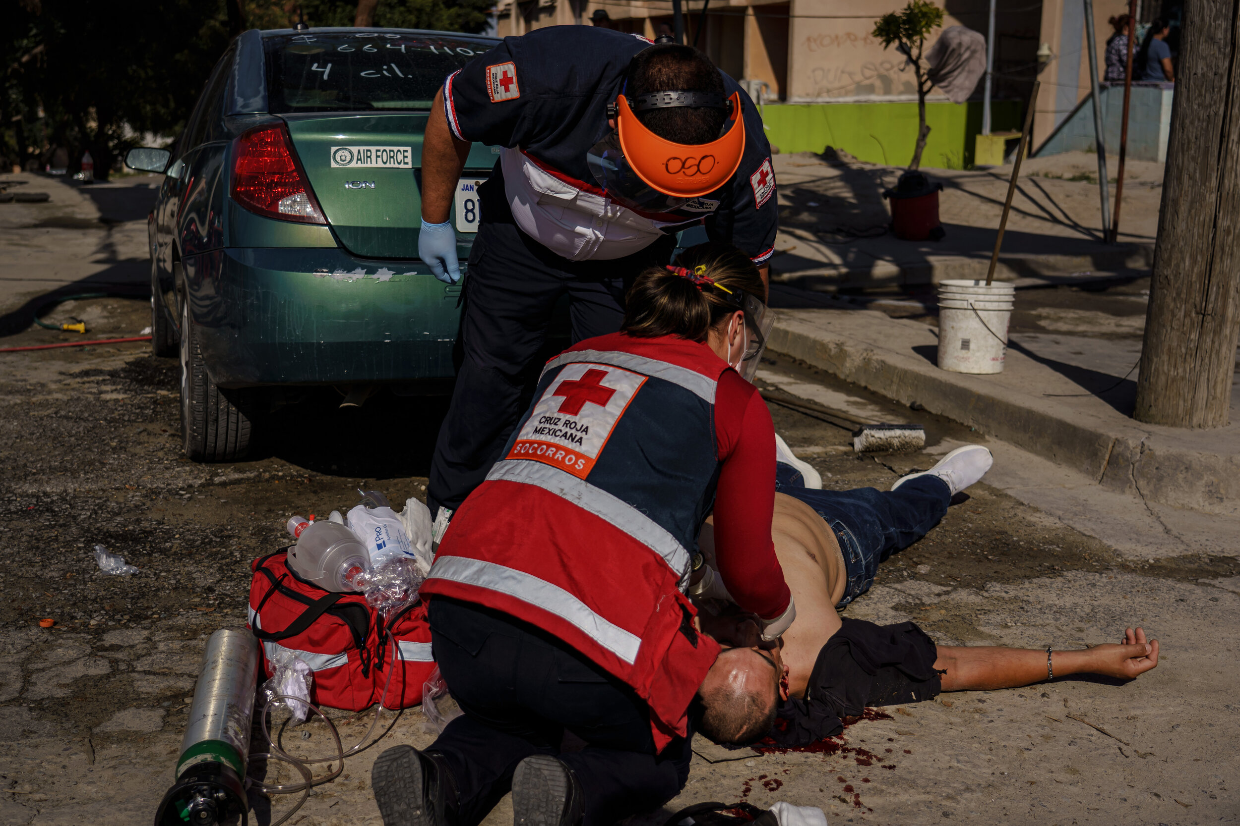  Red Cross paramedics Federico Prez Ramrez and Valeria de la torre Beaven work quickly to stabilize a patient who was shot in the back of the head at a crime scene where three men were gunned down, in Tijuana, Mexico, on April 28, 2020. Even before
