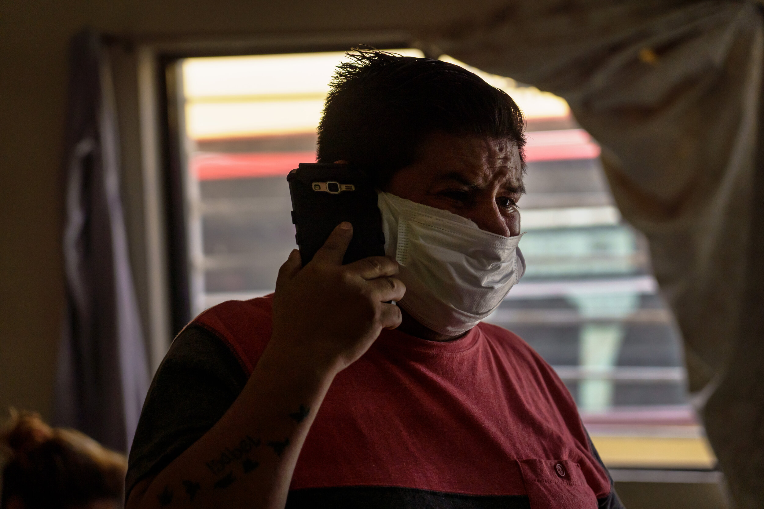  Guillermo Dionisio Molina, tears up as he talks on the phone and watches the Red Cross paramedics transport his brother, Eduardo Dionisio Molina, 41, who has symptoms related to COVID-19, to a nearby hospital from their home in the Pobladoejido Mata