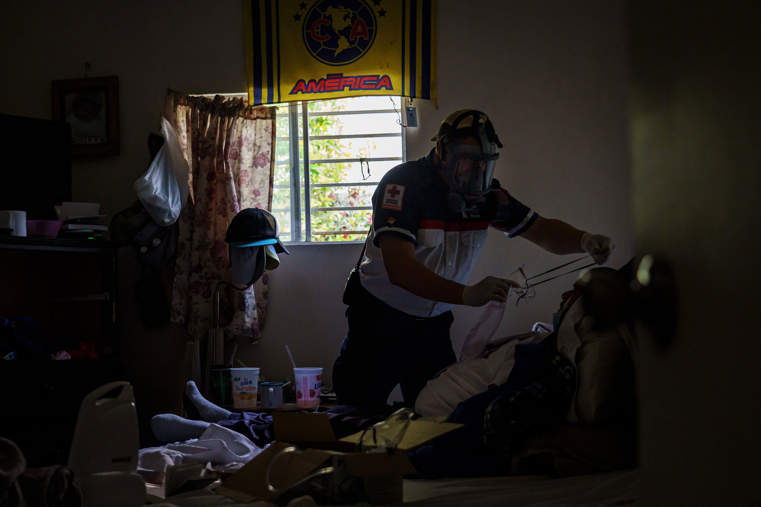  Sergio Garcia prepares an oxygen mask for  a patient exhibiting COVID-19 symptoms and readies the patient for medical transport in the Pobladoejido Matamoros neighborhood of  Tijuana, Mexico, on April 29, 2020.  