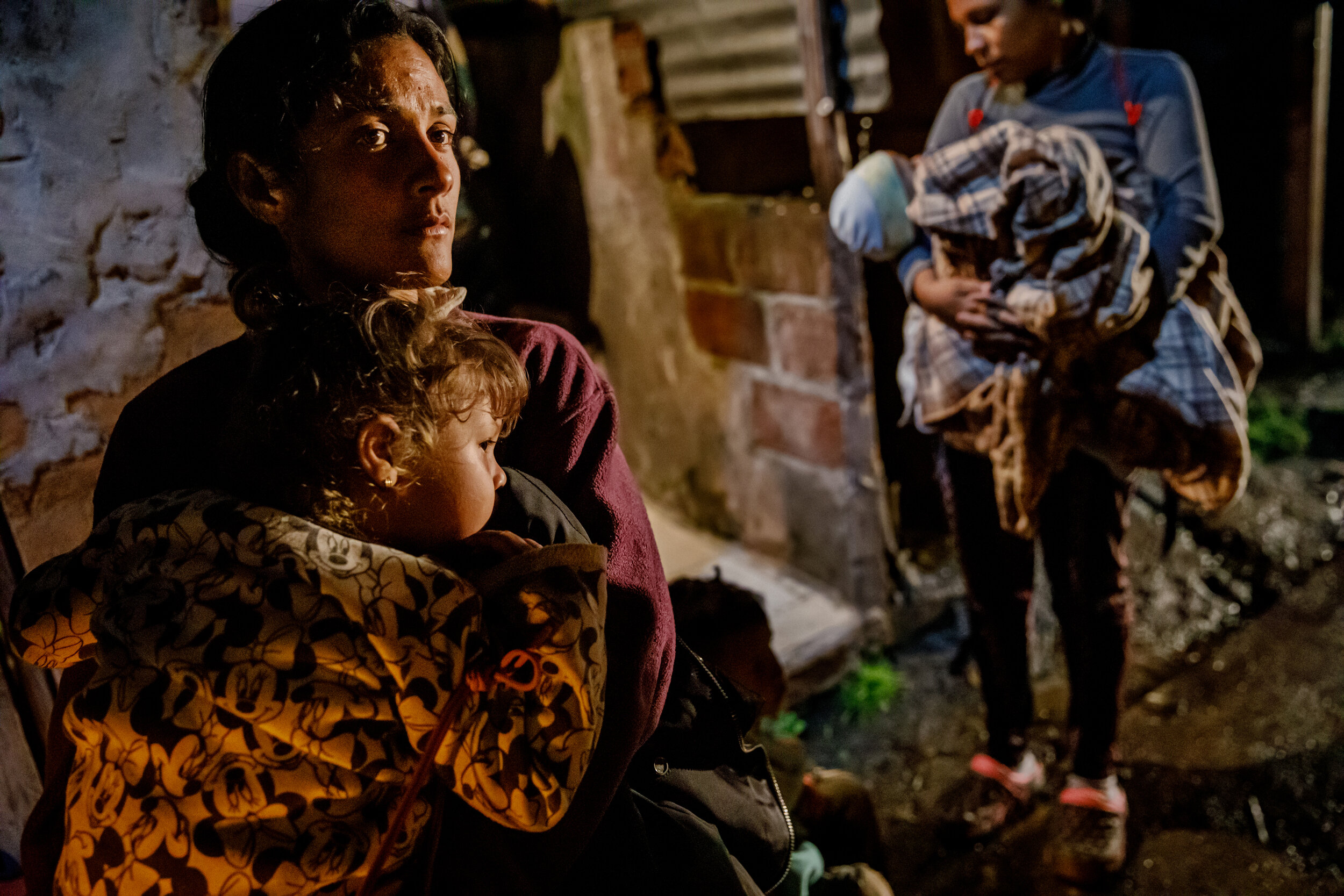  Migrant mothers holding their children watch as others disembark from the truck that transported them through the cold plateau, known as El Pramo de Berl’n the most dangerous part of the Andes to get to the other side, on the outskirts of Bucaramang