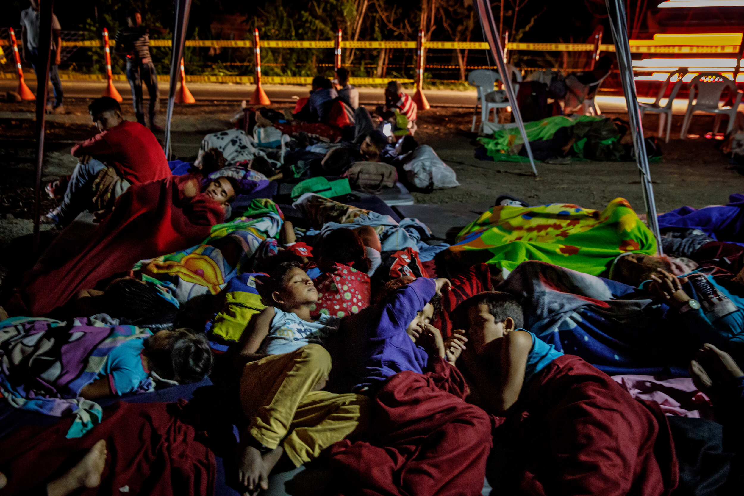  Venezuelan children sleep on the ground after their families arrive on foot at the campground in Bochalema, Colombia. All around them, other travelers arranged thin blankets on the uneven dirt amid chatter of backaches and blisters and the cold. The