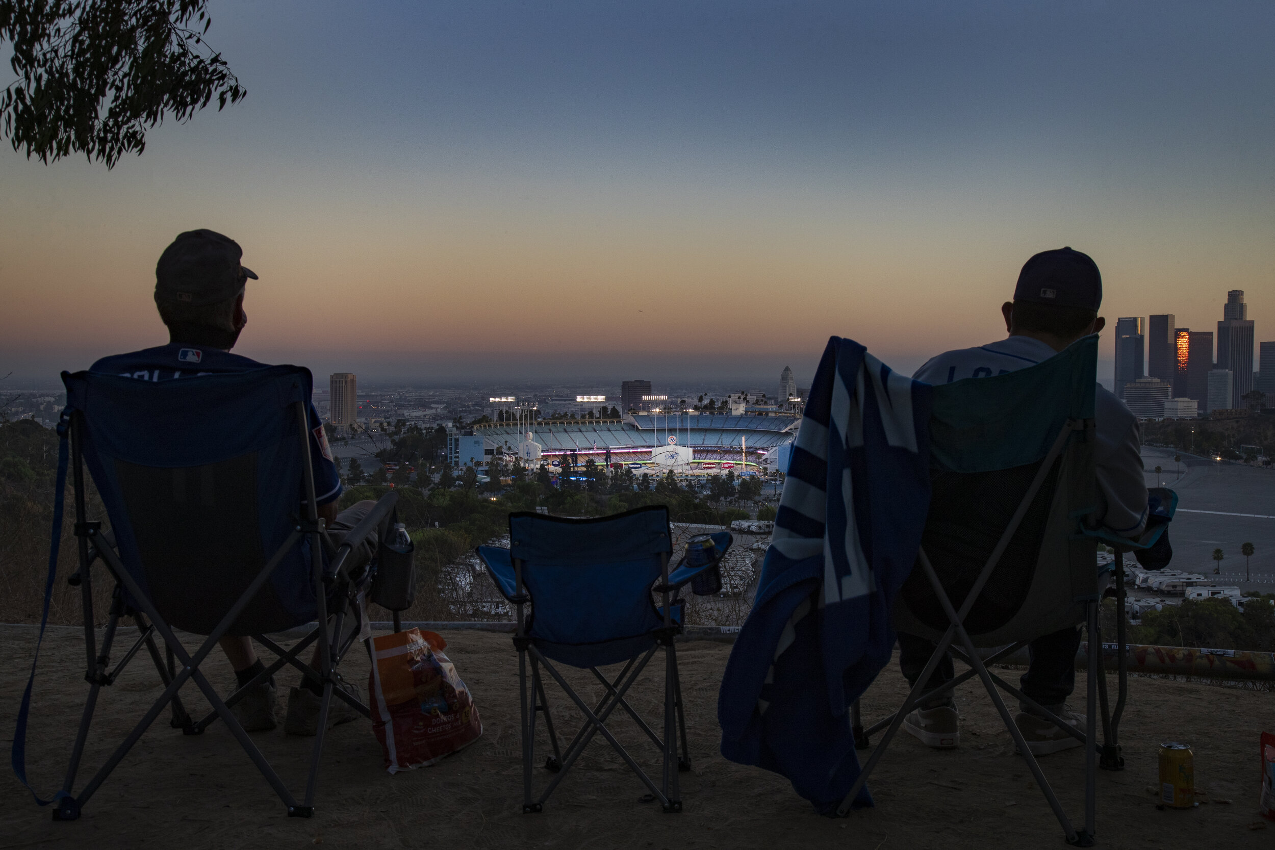  LOS ANGELES, CA - AUGUST 8, 2020: Season ticket holder Keith Hupp, left, and David Lopez, right, watch the Dodgers play the San Francisco Giants from a far overlook spot because of the coronavirus pandemic in Elysian Park on August 8, 2020 in Los An