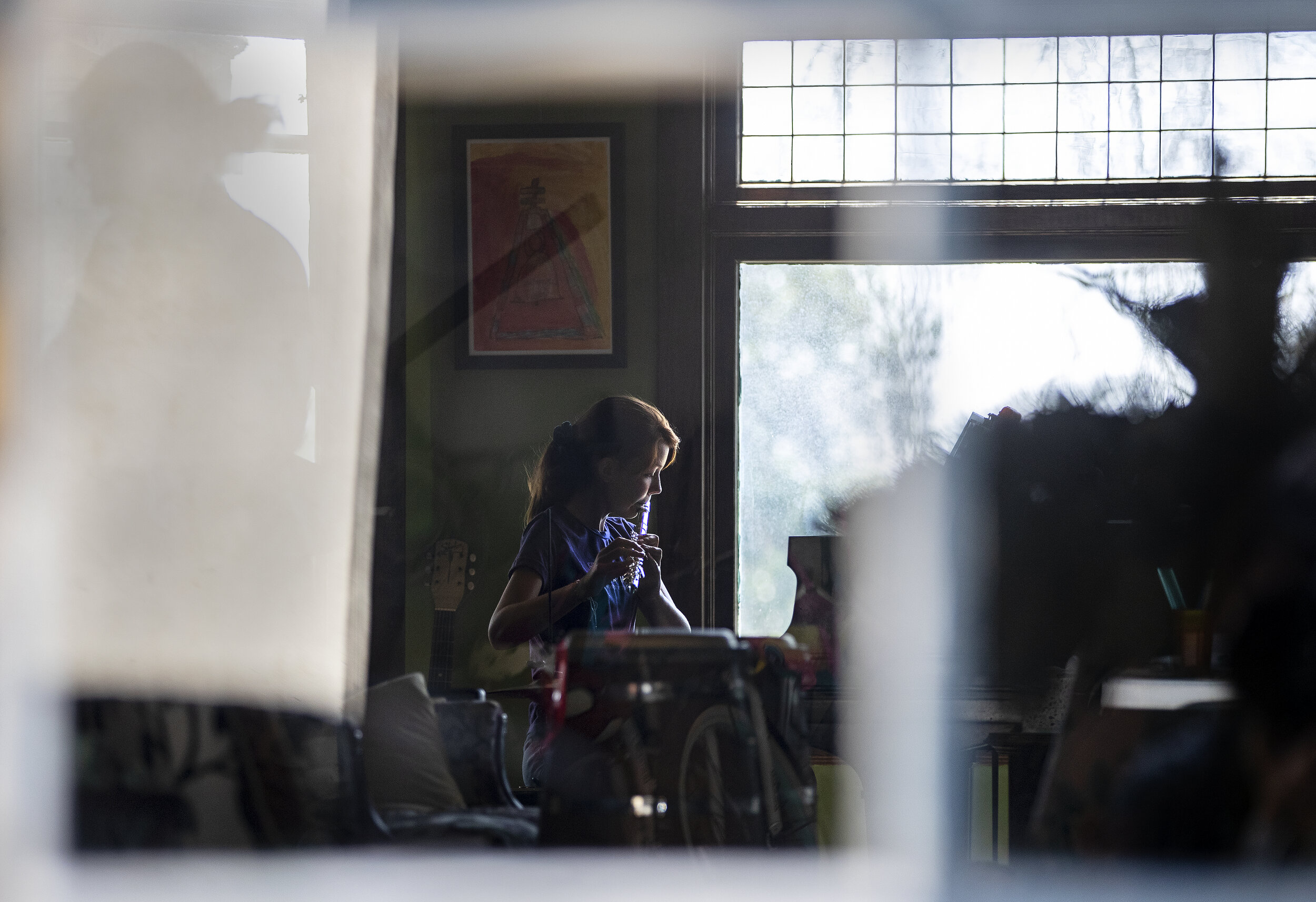  RIVERSIDE, CA- APRIL 29, 2020: Kat Bristow, 12, sits at the piano in the Roth’s living room playing the flute during music class taught by her neighbor music producer Gabe Roth during home school in the midst of the coronavirus pandemic on April 29,