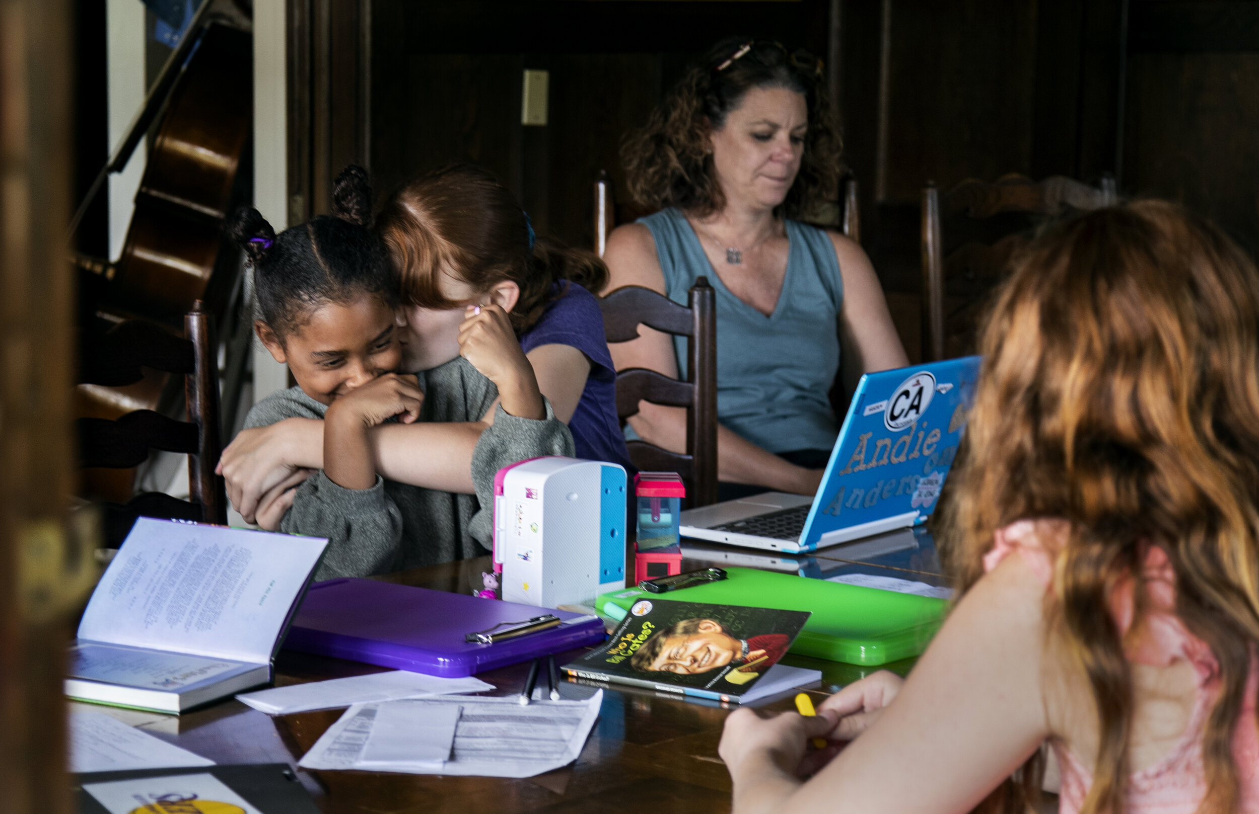  RIVERSIDE, CA- APRIL 29, 2020: Kat Bristow, 12, snuggles her sister Andie, 6, while they team up for a science presentation during home school in the midst of the coronavirus pandemic on April 29, 2020 in Riverside, California. Their mom, former thi