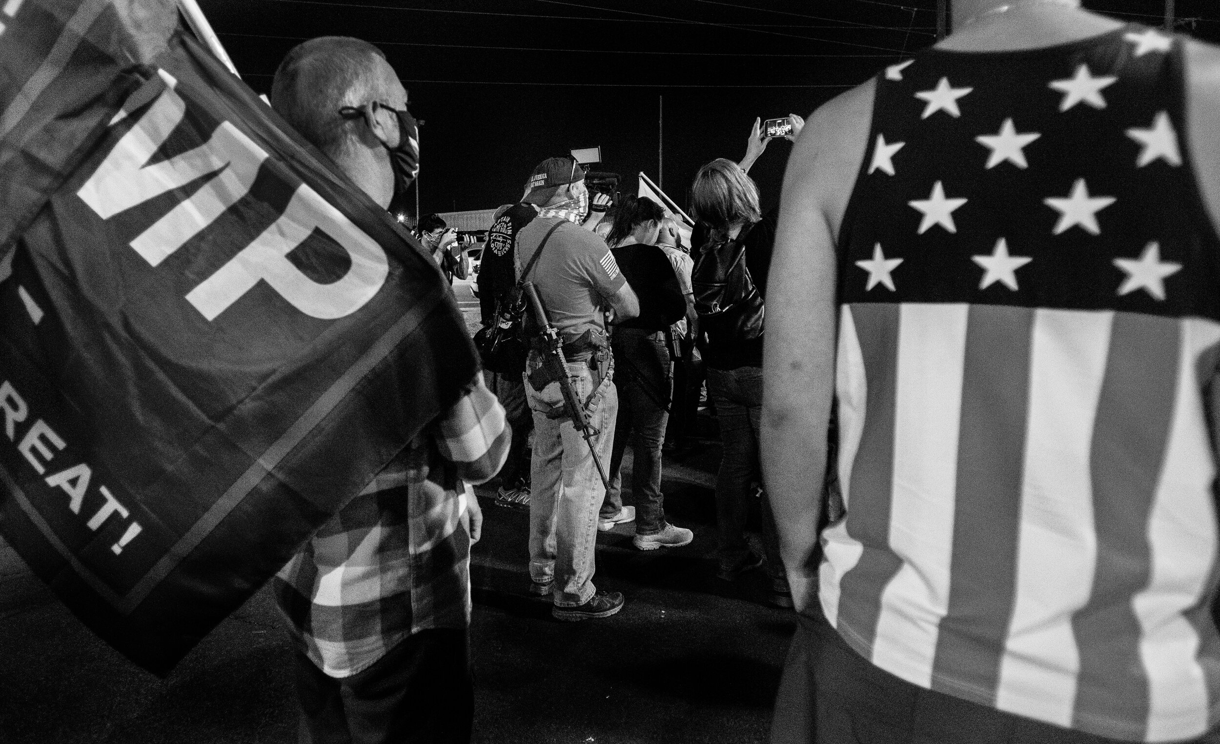  PHOENIX, AZ - NOVEMBER 5, 2020:  Trump supporters brought their guns, Trump flags and patriotic shirts to protest in the parking lot at the Maricopa  County Tabulation and Election Center as ballots continue to be counted inside the building  on Nov