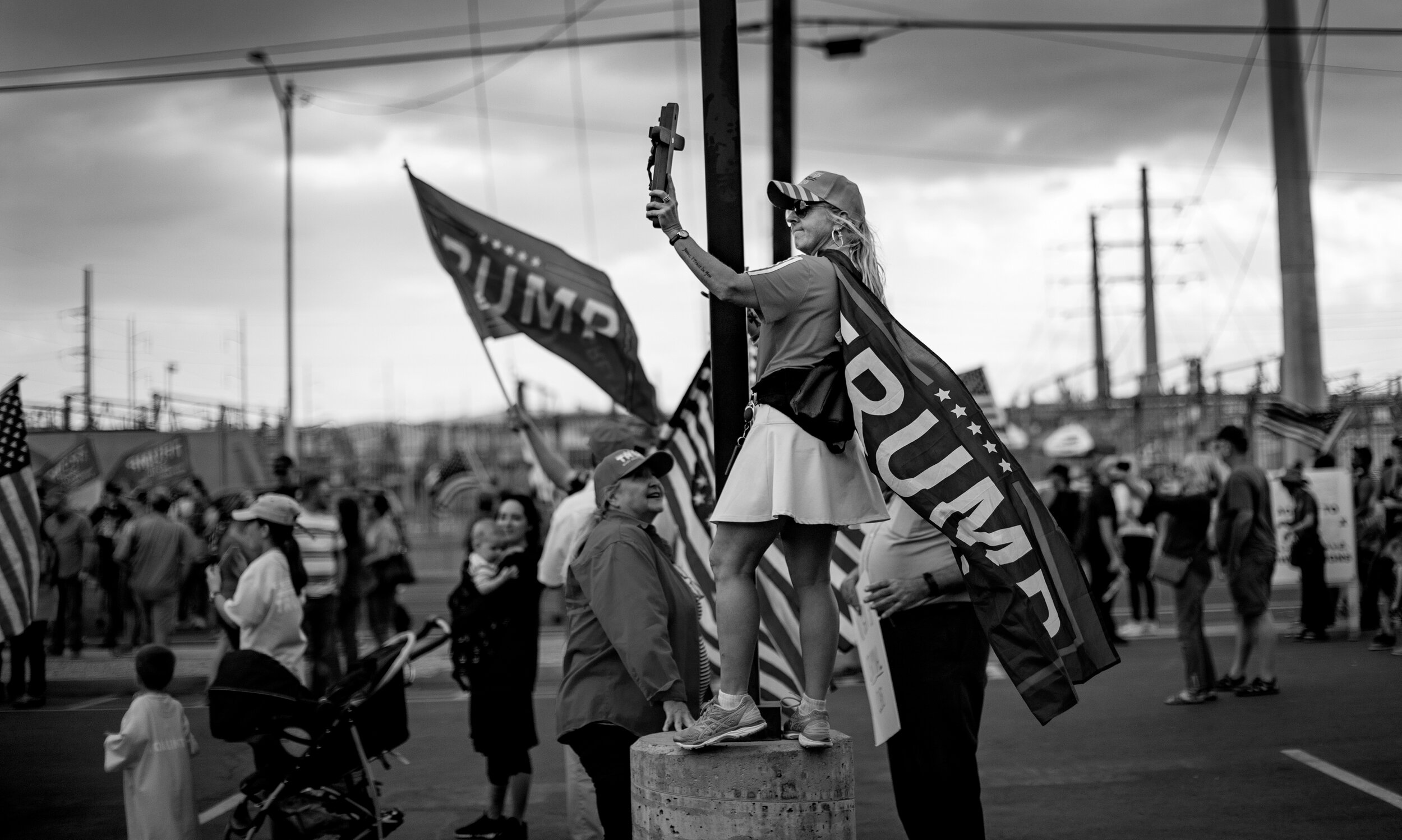  PHOENIX, AZ - NOVEMBER 7, 2020: As storm clouds move in,  a Trump supporter holds a cross up to the sky while attending a pro-Trump rally to defy the election results hours after  Biden was named President-elect  outside the Maricopa County election