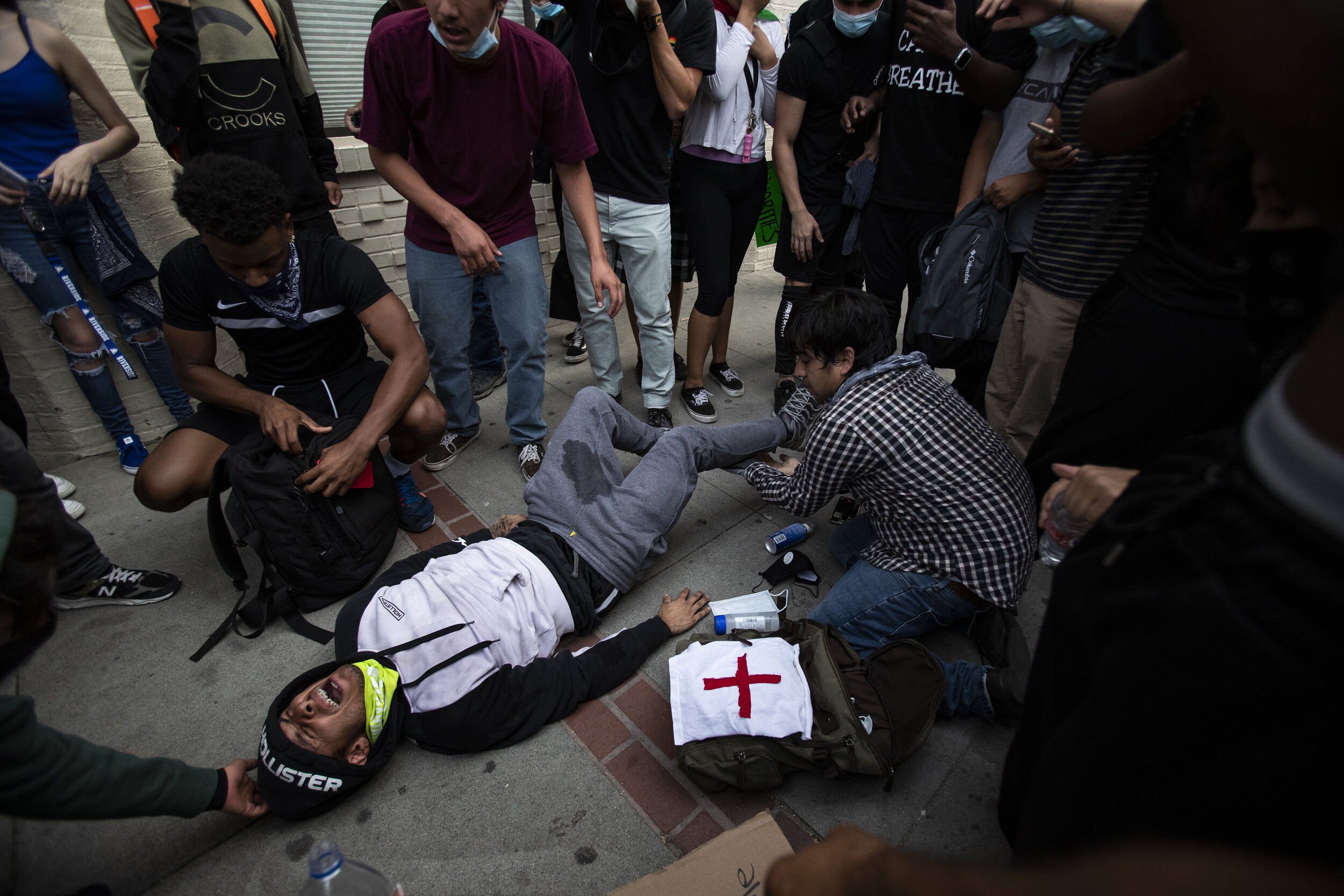  RIVERSIDE, CA - JUNE 1, 2020: A demonstrator screams in pain after being injured while running from plastic rounds fired by Riverside County Sheriffs to push back protesters  who refused to disperse after curfew during a protest against the death of