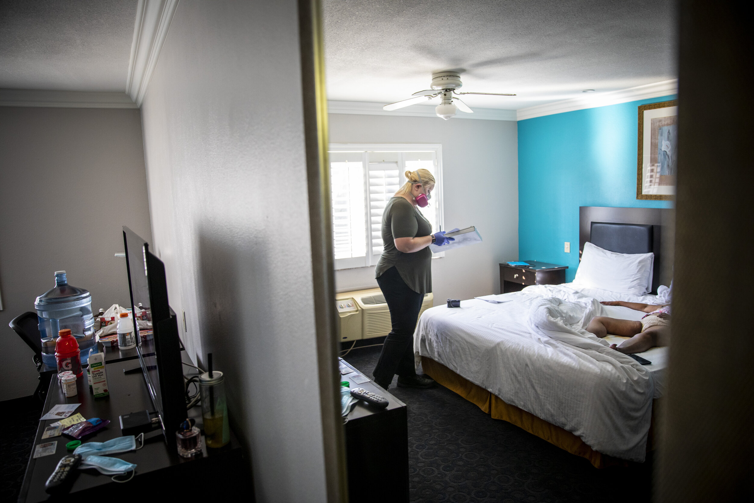  Kristina McGuire, an investigator with the Los Angeles County Dept. of Medical Examiner-Coroner, exams the lifeless body of Judy Bounthong, 58, an ob-gyn tech at Emanate Queen of the Valley Hospital, at the Days Inn by Wyndham, in West Covina, CA, o