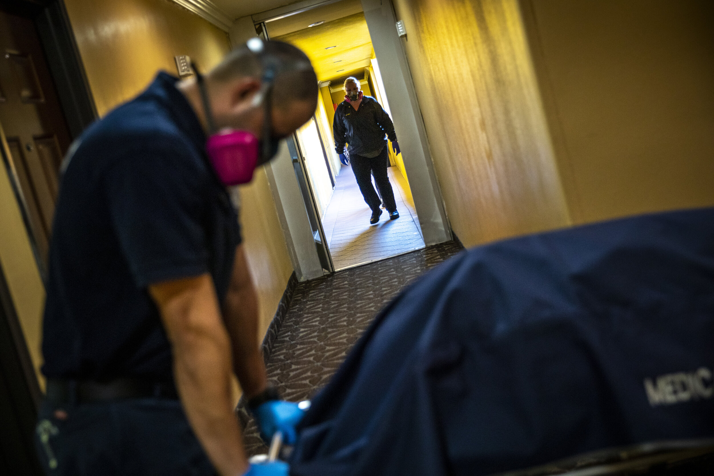  Kristina McGuire, an investigator with Los Angeles County Dept. of Medical Examiner-Coroner walks toward Jerry Meza, forensic attendant, to help move the gurney carrying the lifeless body of Judy Bounthong, 58, an ob-gyn tech who died of coronavirus