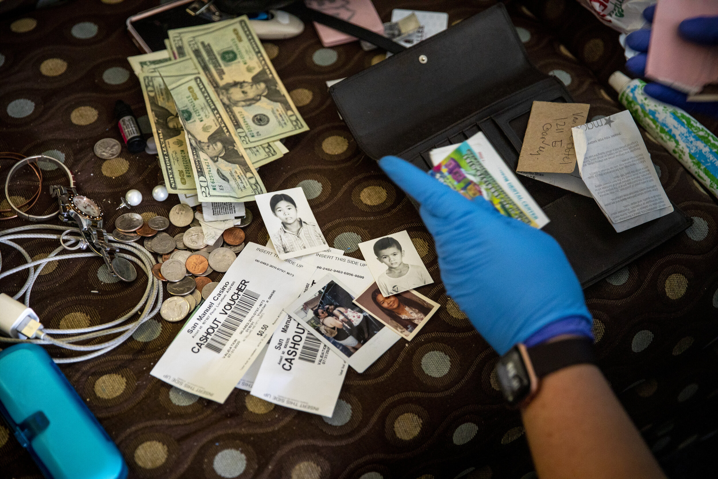  Kristina McGuire, an investigator with the Los Angeles County Dept. of Medical Examiner-Coroner, combs through belongings, looking for clues about the life of a deceased Judy Bounthong, 58, an ob-gyn tech, found dead in her room at the Days Inn by W