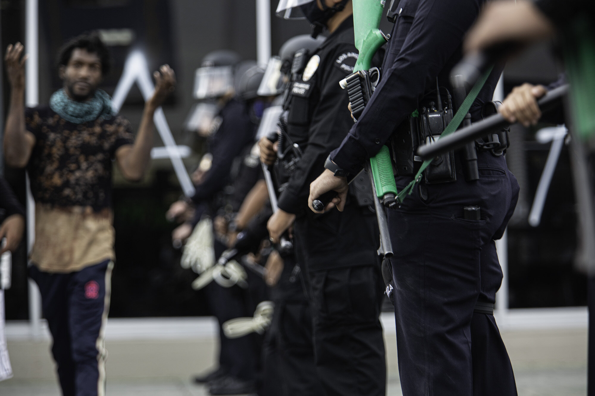  A Protestor walking in front of the police officers during a demonstration in Fairfax District, organized by Black Lives Matter following the death of George Floyd on May 30, 2020 in Los Angeles, Calif.  