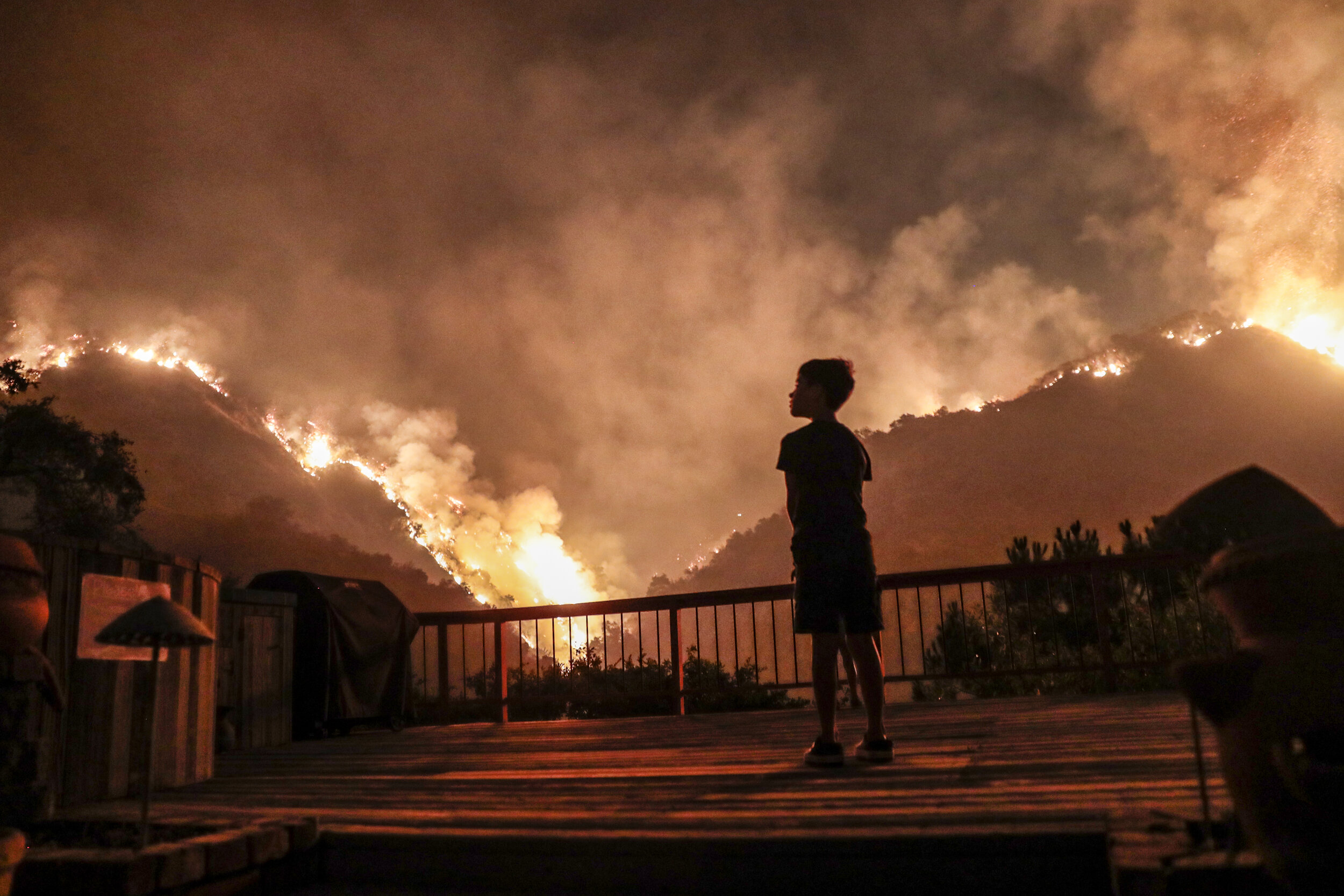  Monrovia, CA, September 15, 2020 - Castle Snider, 8, looks on as flames engulf the hillsides behind his backyard as the Bobcat Fire burns near homes on Oakglade Dr.   