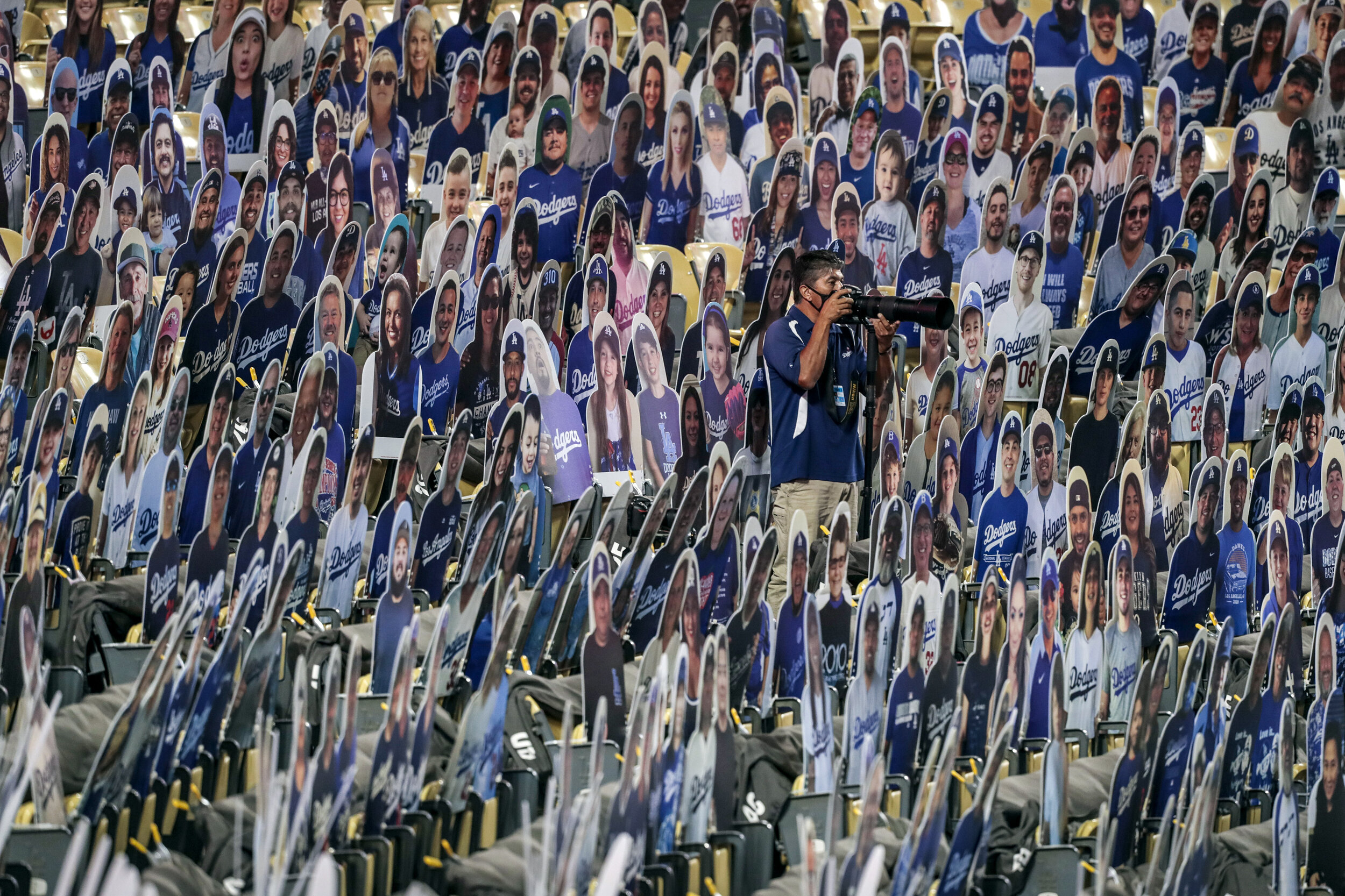  Los Angeles, CA, Sunday July 26, 2020 - Dodgers team photographer Juan Ocampo photographs the action from field level seats occupied by hundreds of fan photos during a game against the Giants at Dodger Stadium.  