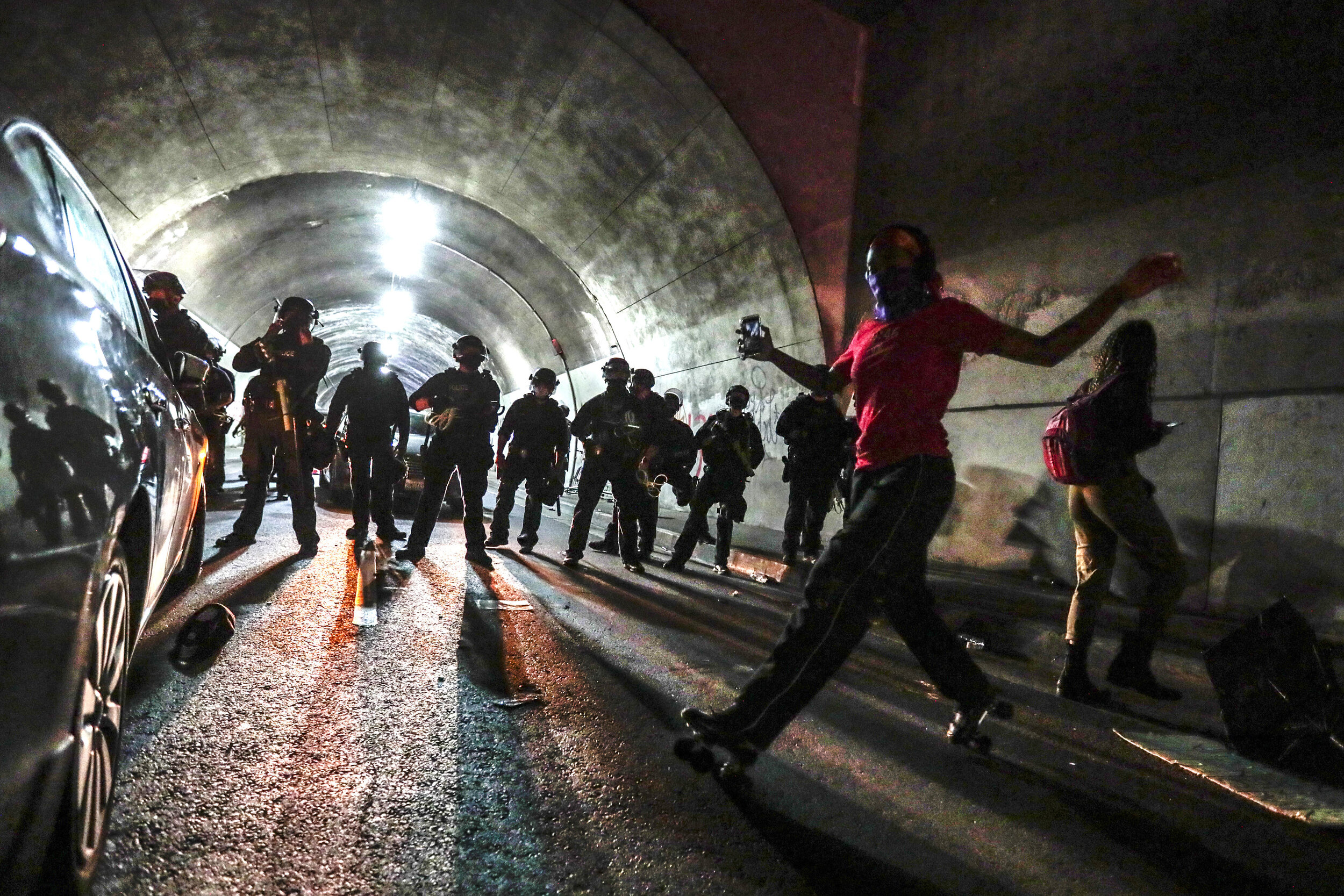  Los Angeles, CA, August 26, 2020 - Liliana Ruiz roller skates in front of a phalanx of LAPD officers as Black Lives Matter protesters are pinned in the Third St. tunnel, downtown.  