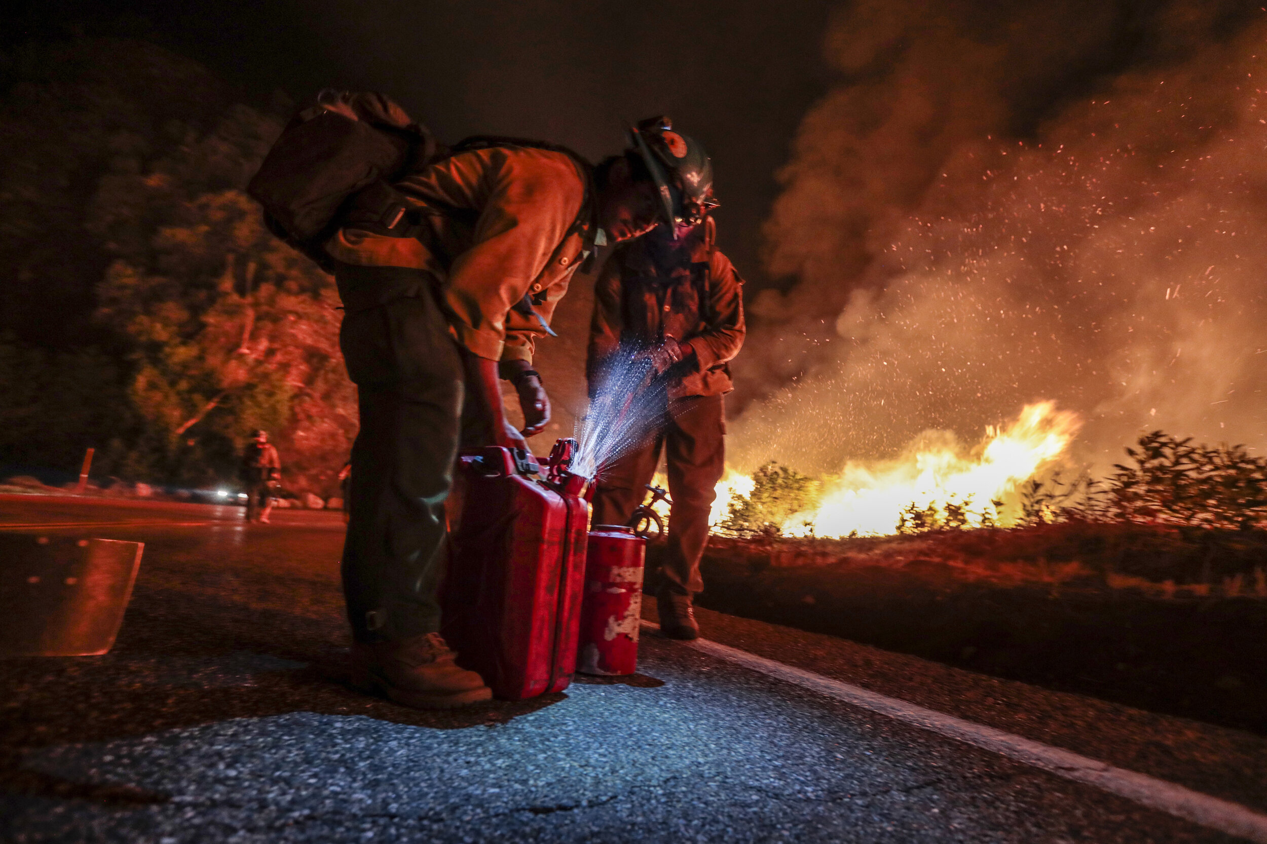  Firefighter Juan Quiroga handles a gas can as members of the Blue Ridge, Arizona hot shot crew prepare to execute a burn out operation on the Bobcat Fire.  A combination of dry brush, steep terrain and high winds, the fire burned for nearly four mon