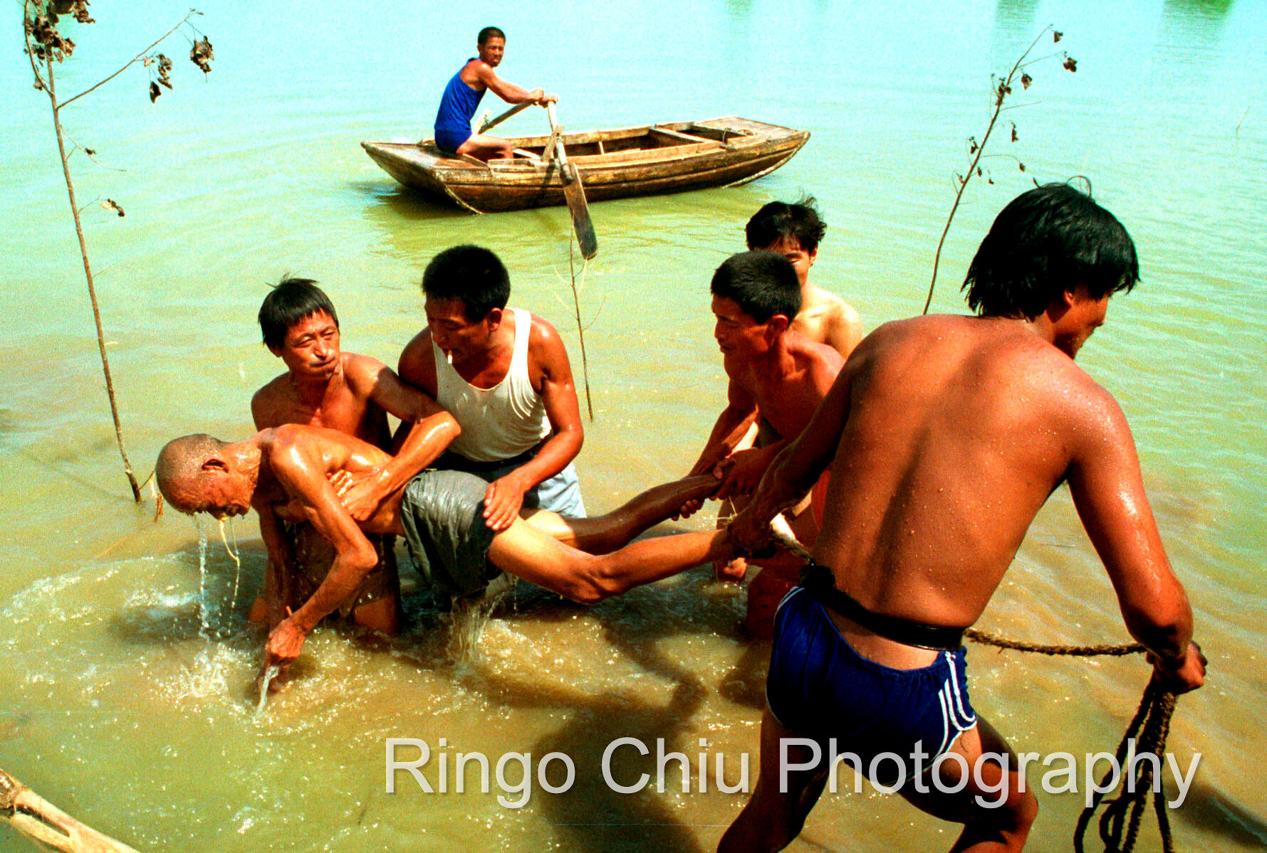  The body of a drowned villager is recovered from flood waters after heavy rains swept through Southern China. China. (1991). 