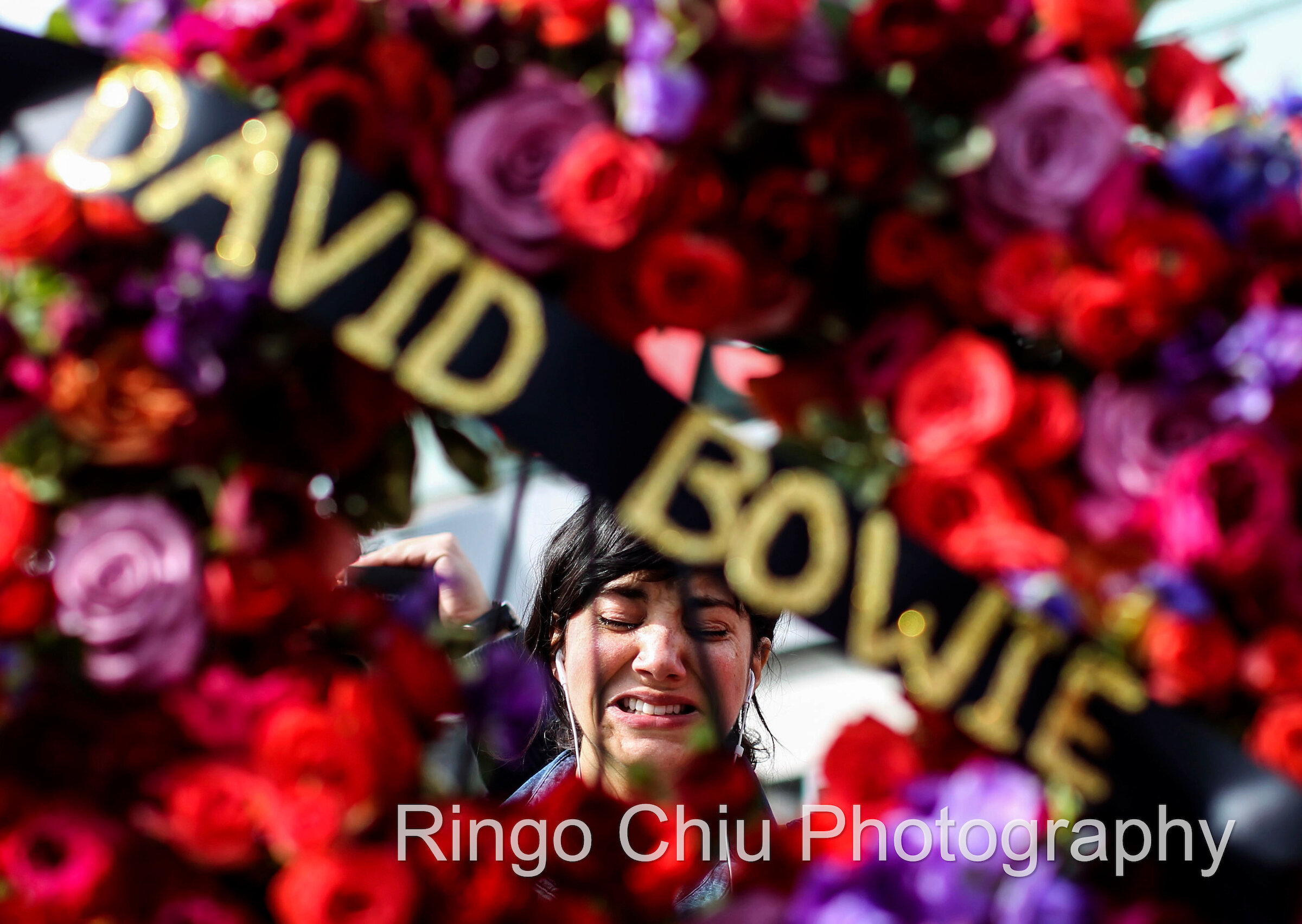  A fan cries behind a wreath at a makeshift memorial surrounds David Bowie's star on the Hollywood Walk of Fame in Los Angeles, Monday, Jan. 11, 2016. 