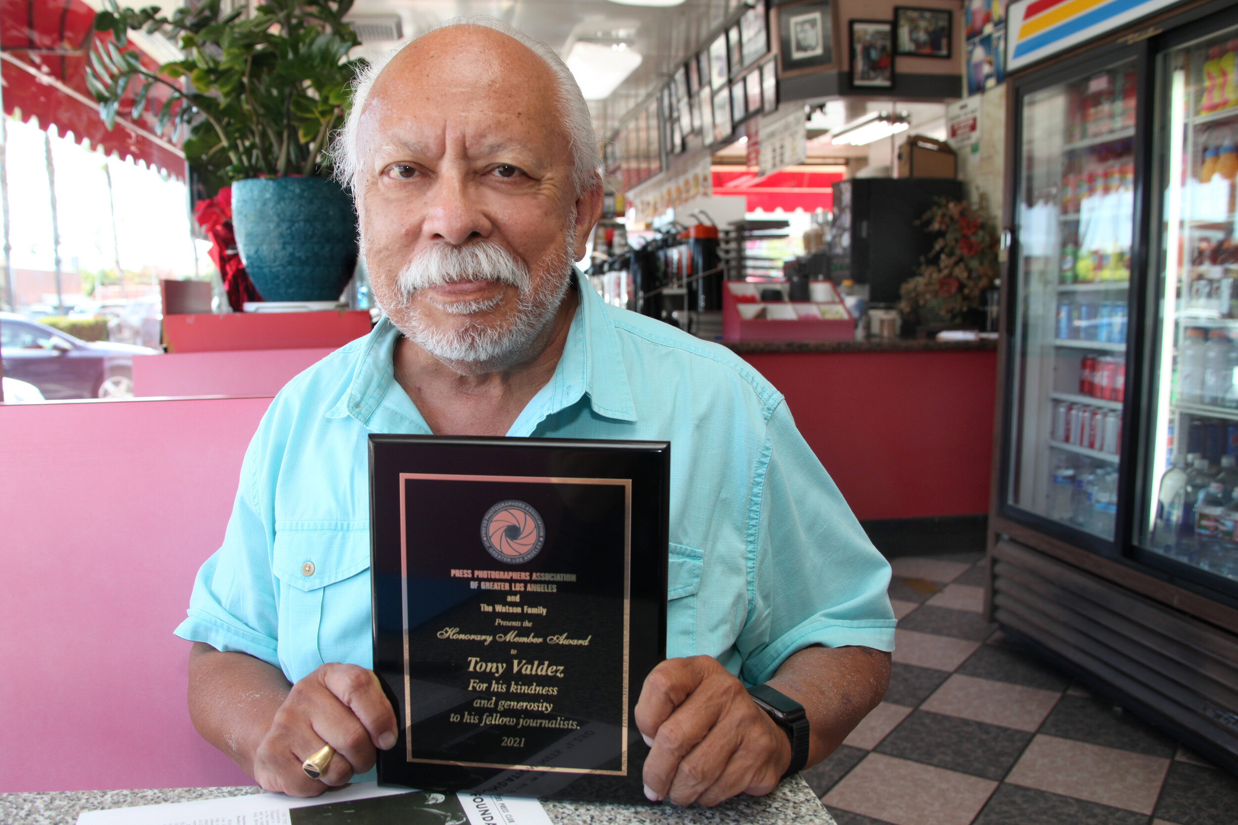  Tony Valdez, long-time Los Angeles television news reporter and PPAGLA's newest Honorary Member, receives his plaque at a pandemic "office." 