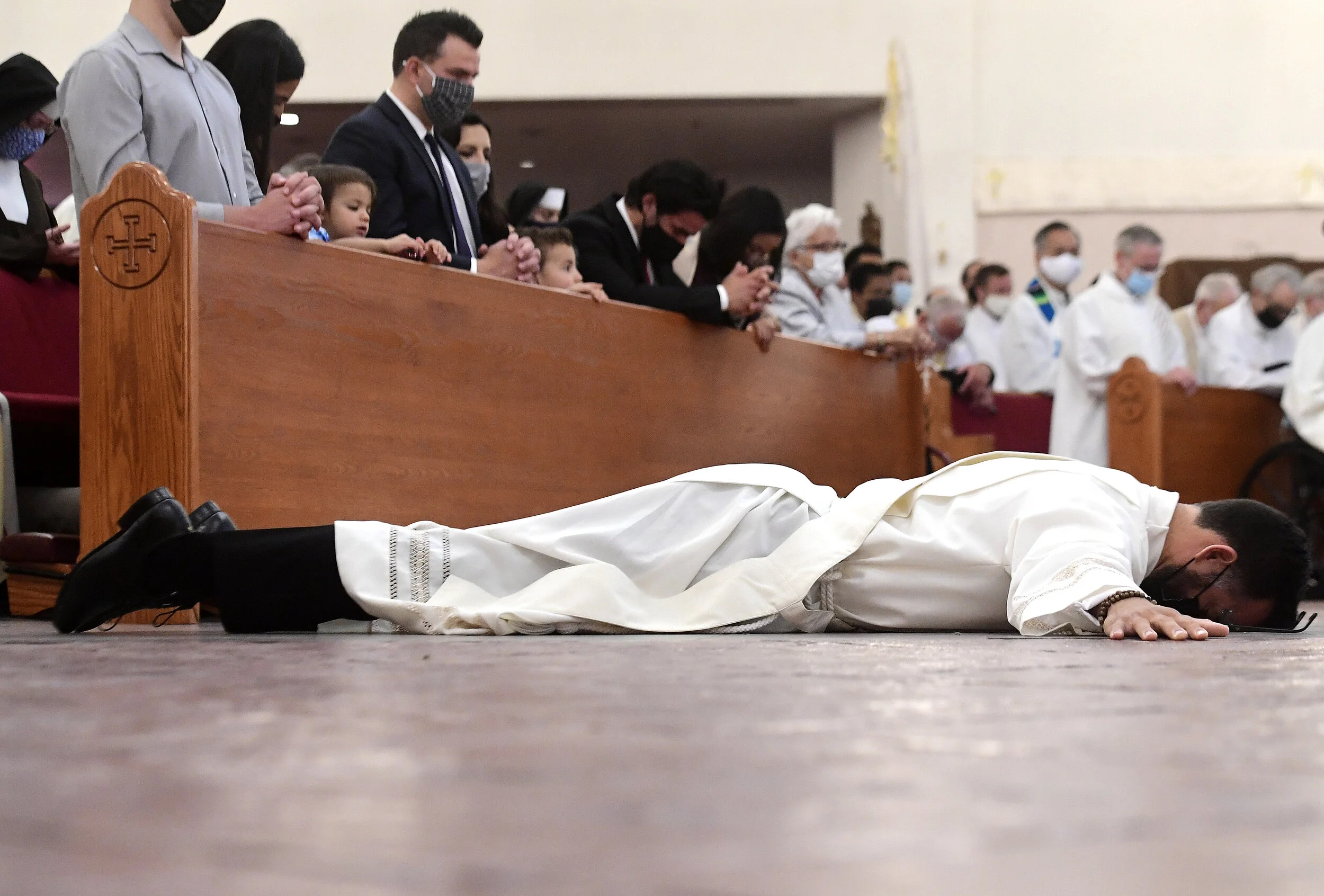  Deacon Ian Francisco Hollick, 34 from Corona, lies on the floor in the shape of the cross during the Litany of Supplication portion of his Ordination to the Priesthood mass at Sacred Heart Church in Rancho Cucamonga Saturday morning May 29, 2021. Fa