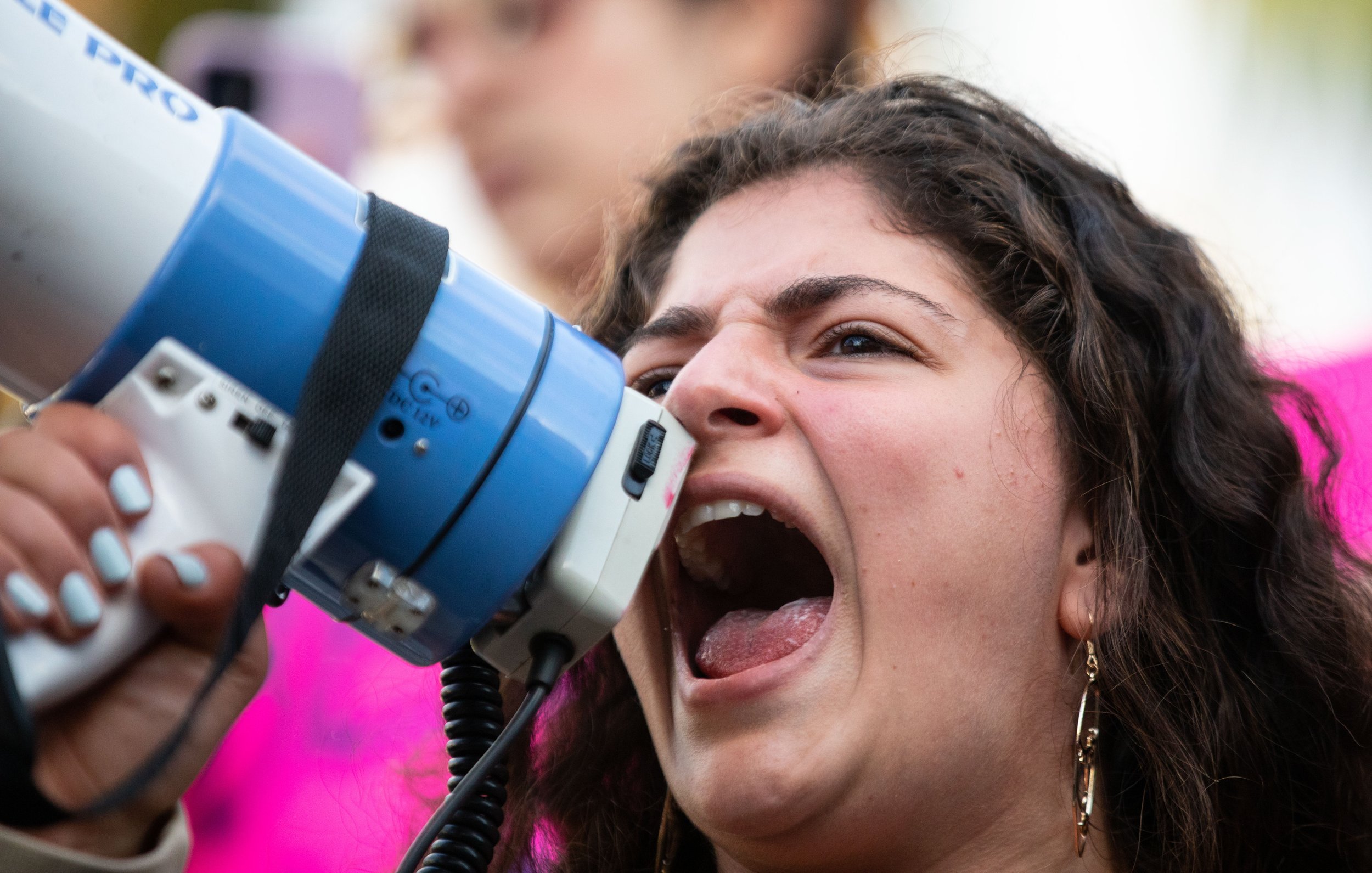  Nour Myra Geha chants into a megaphone Oct. 25, 2021, while leading a large crowd from USC Village to the Sigma Nu fraternity house to protest recent reports of sexual assault. (Photo by Yannick Peterhans) 