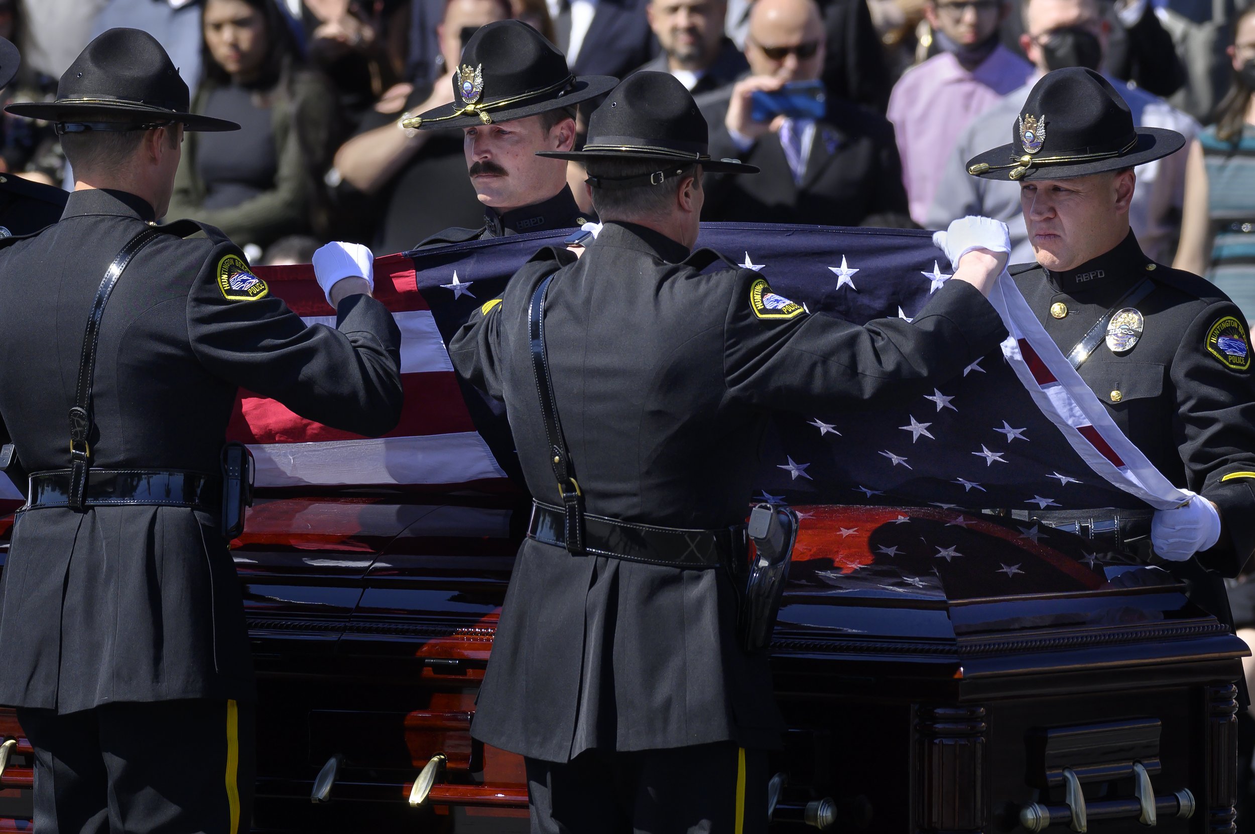  Huntington Beach Police Officers remove the flag from Officer Nicholas Vella’a casket on Tuesday, March 8, 2022. Vella died in a helicopter crash Feb. 19 off the waters in Newport Beach. He was an 18-year law enforcement veteran with 14 years on the