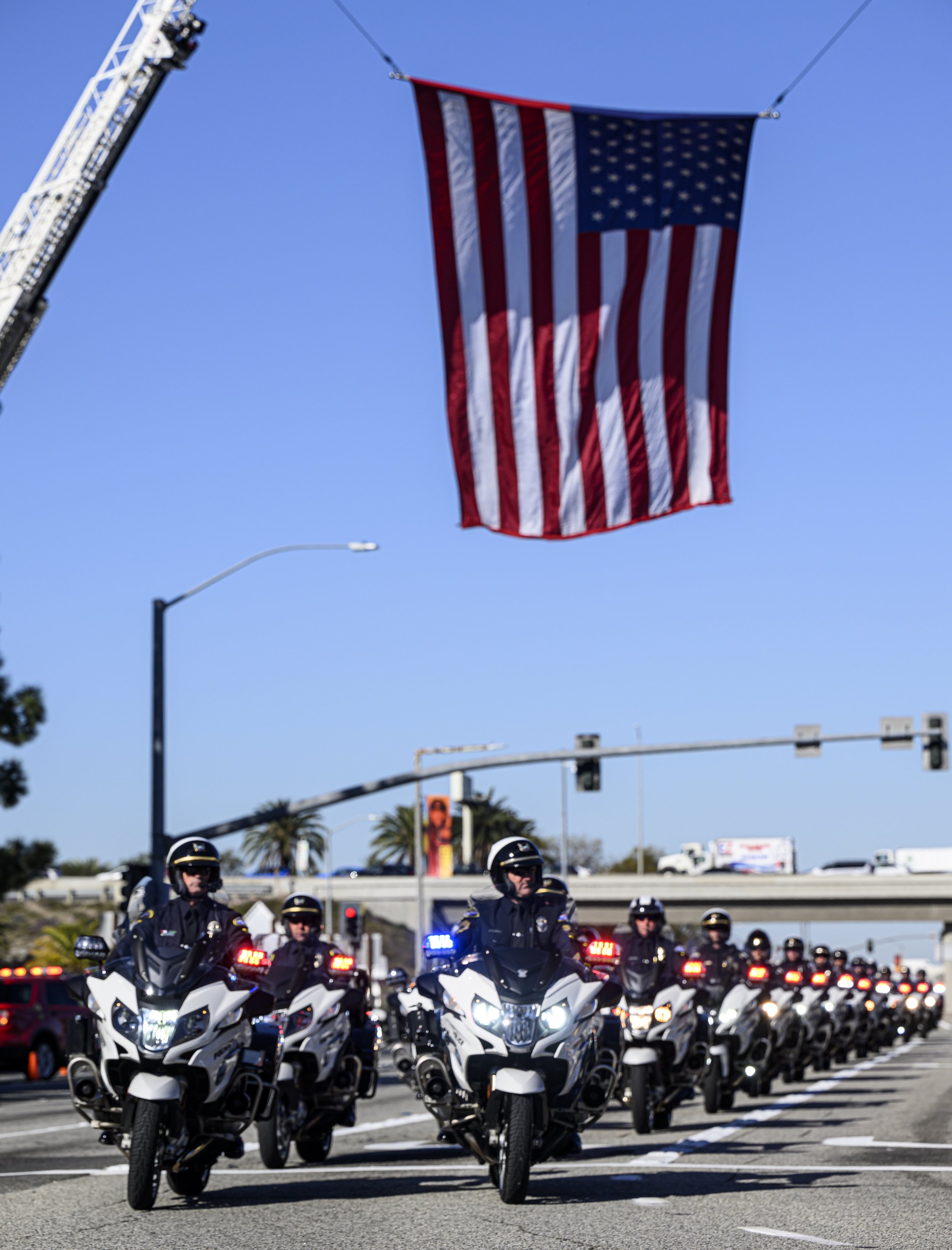  A procession down Katella Avenue in Anaheim takes place for Huntington Beach Police Officer Nicholas Vella on Tuesday, March 8, 2022. Uniformed personnel line the street and salute before the funeral service. Vella died in a helicopter crash Feb. 19