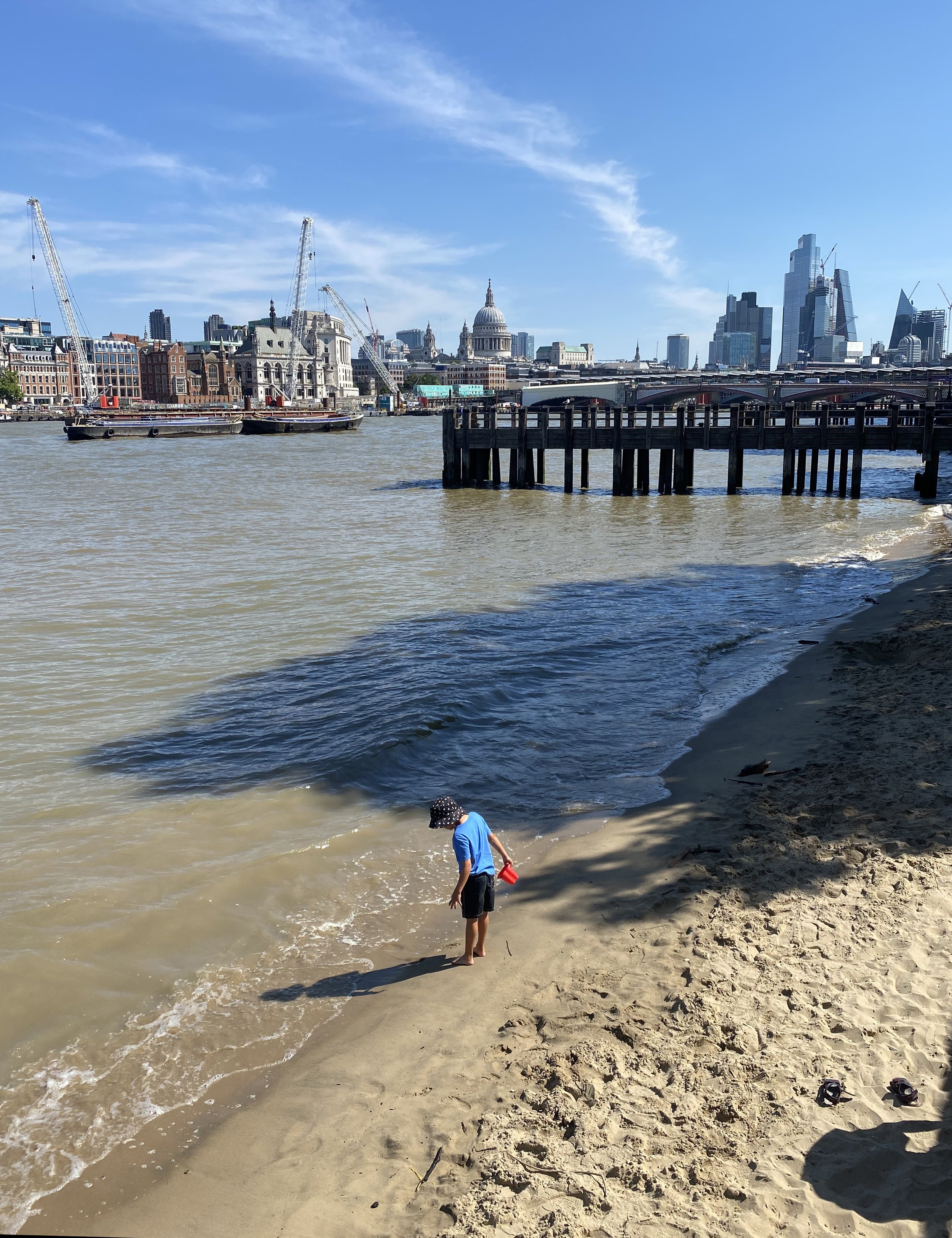  A boy explore a beach on the Thames River Southbank boardwalk.  My parents often walked along the river’s Southbank. 