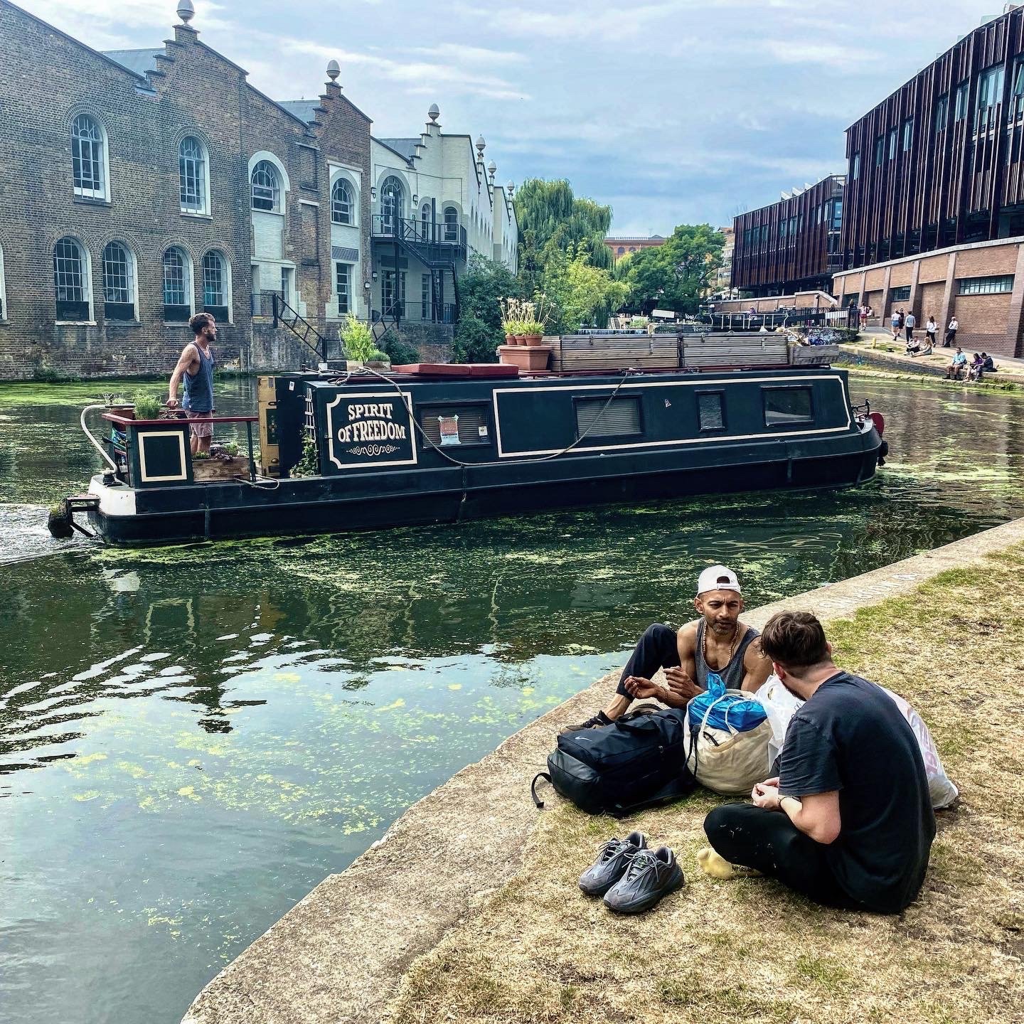  Fred, a London riverboat resident, maneuvers through the lock system on Regent’s Canal as people rest on the bank near Camden Town. 