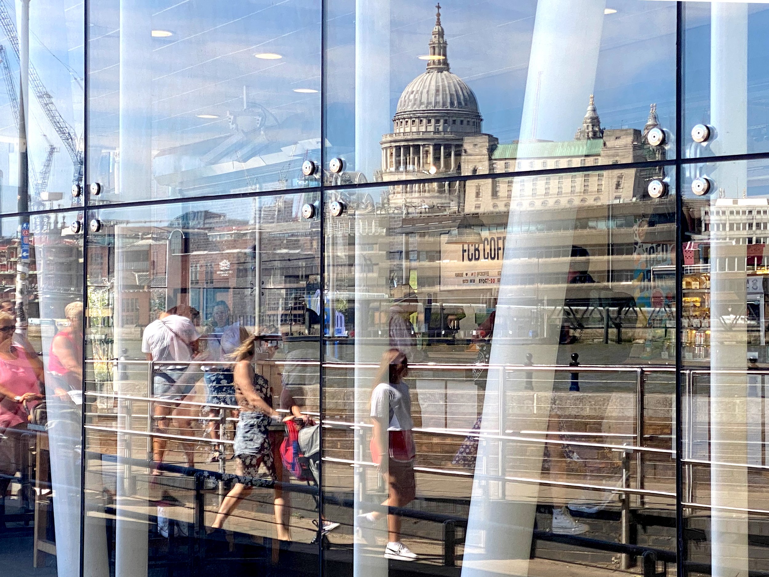  Strollers and St. Paul’s Cathedral are reflected by shop windows along the Thames River Southbank. 