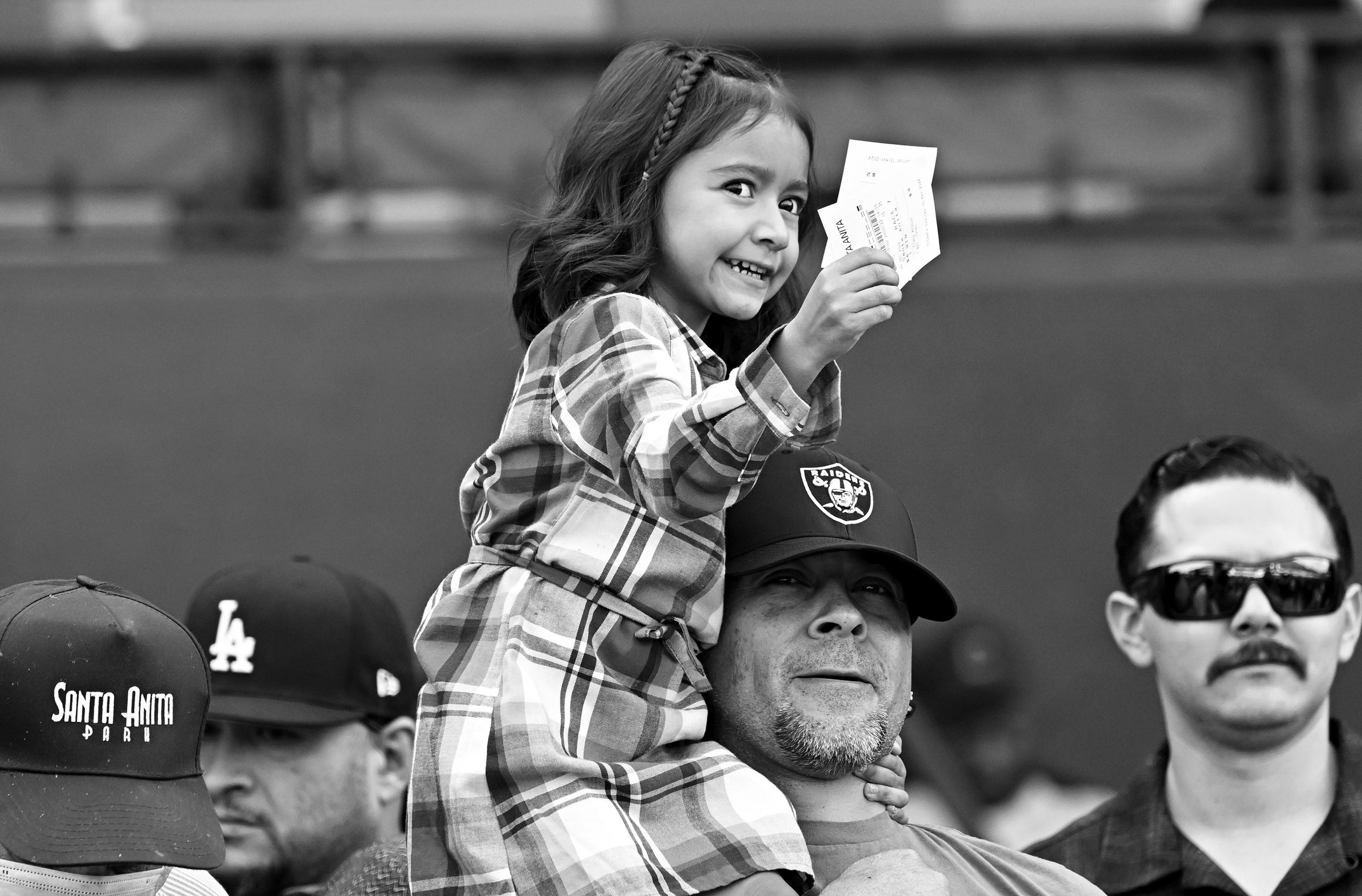 A young fan holds up her fathers betting tickets as jockey Mike Smith (not pictured) wins the Malibu Stakes during Opening day of the winter-spring meet at Santa Anita Park in Arcadia on Monday, December 26, 2022. 