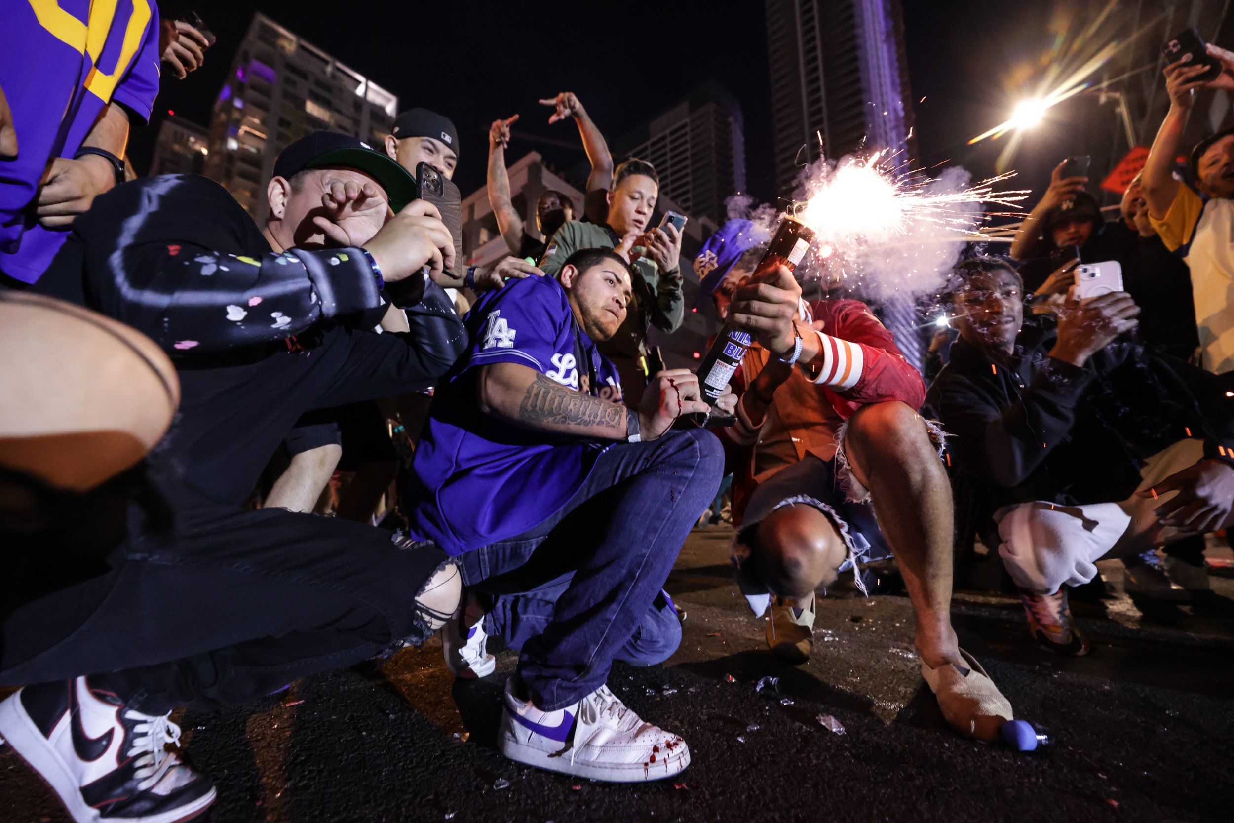  A Los Angeles Ram fan, bleeding from his hand, holds a firework and points it down North Hope Street on February 13, 2021. Hundreds of Angelenos flocked to the streets of Downton Los Angeles after the Rams 2022 Super Bowl win, setting off fireworks 